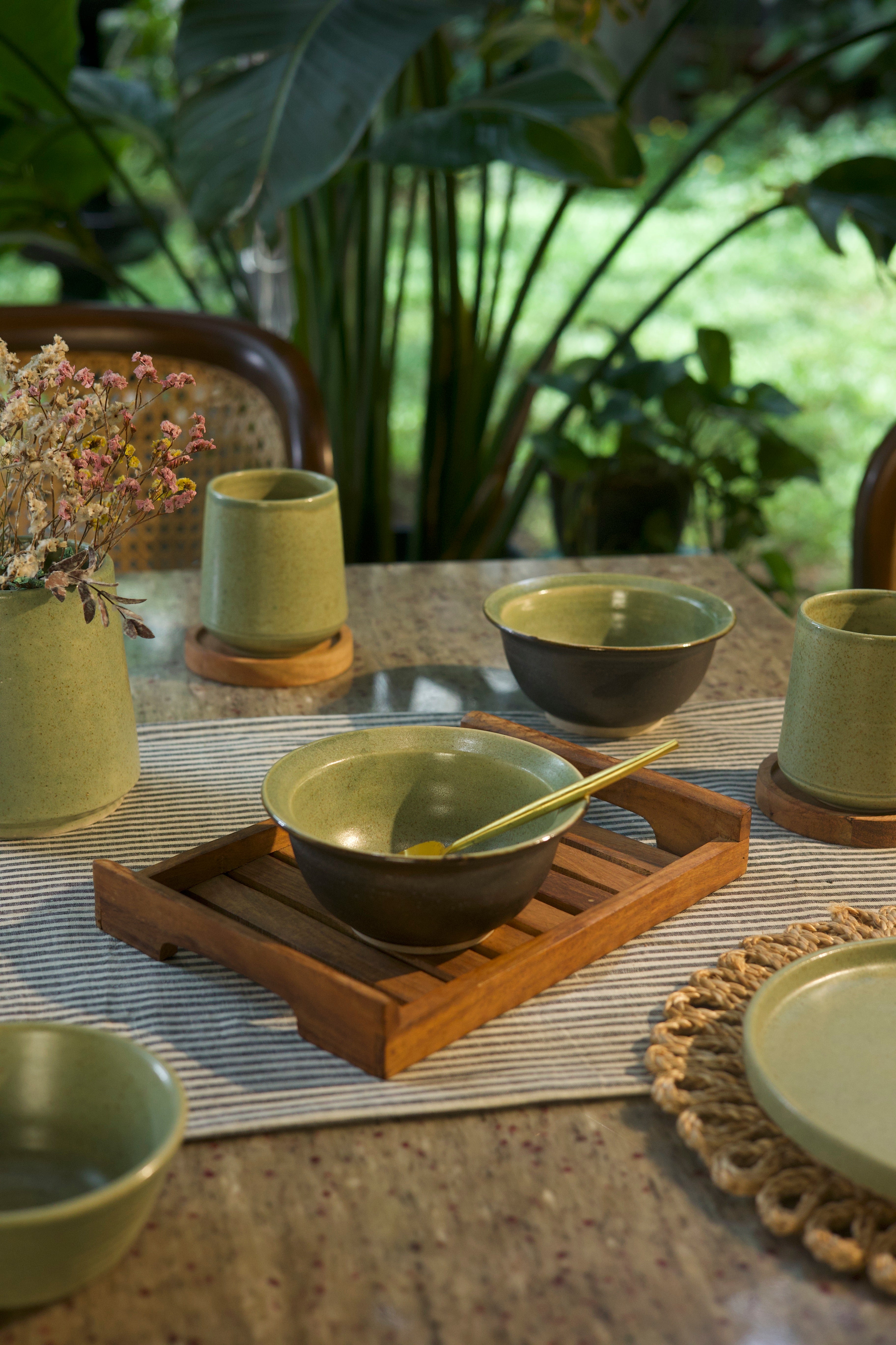 Green ceramic bowls and cups on a table, artisanal serveware India,
handcrafted plates and bowls