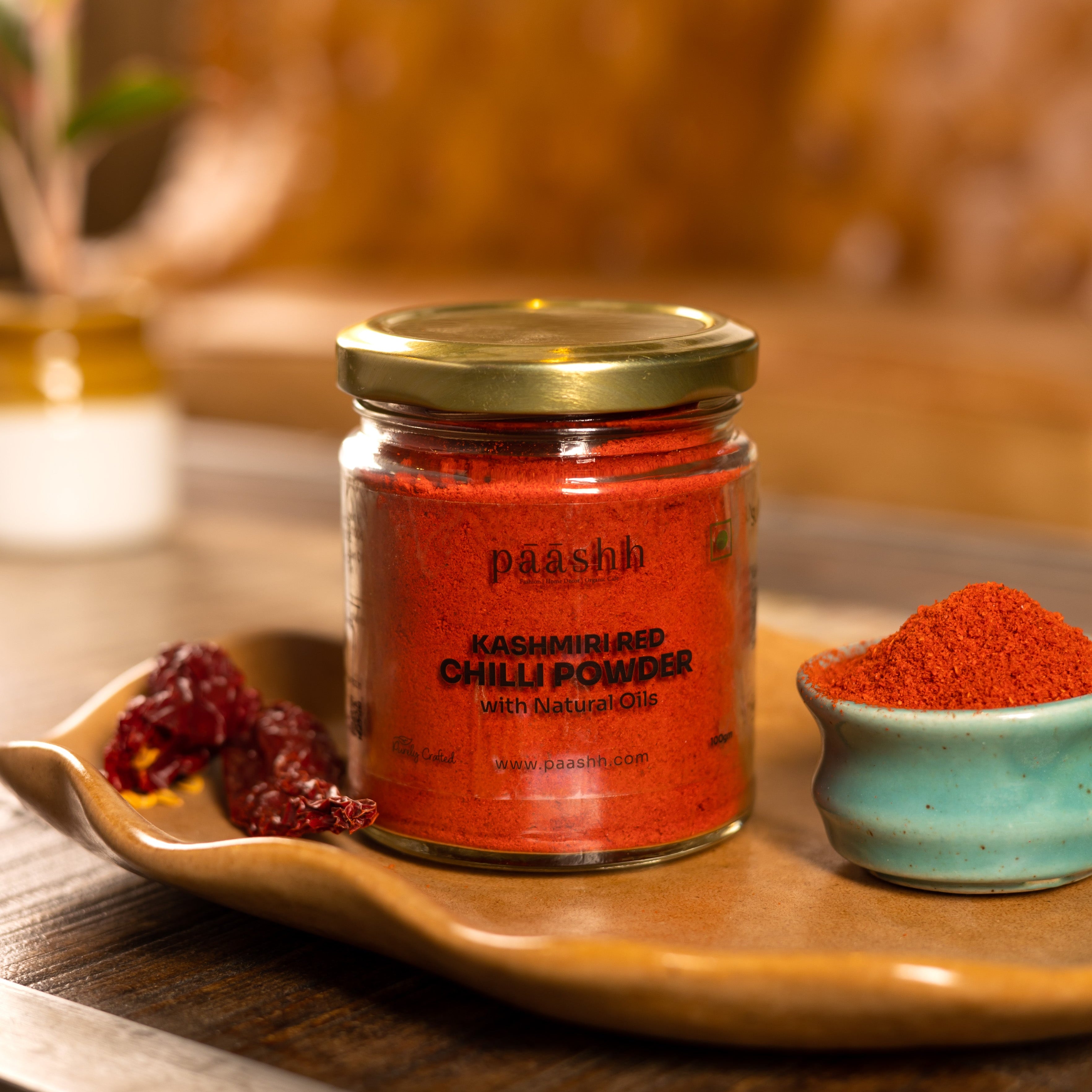 Jar of Paashh Kashmiri Red Chilli Powder on a wooden tray, organic spices India, organic kitchen ingredients