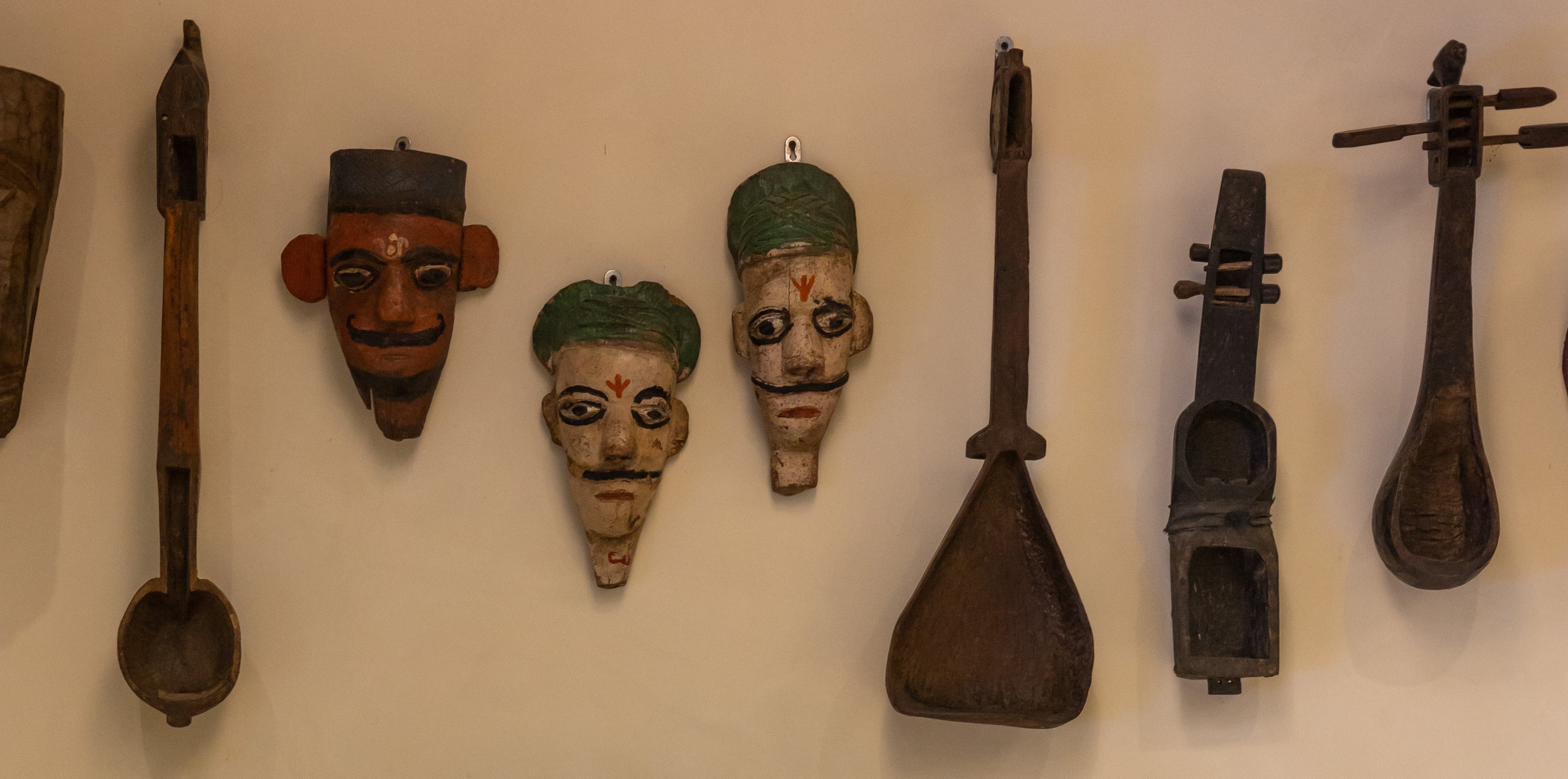 Decorative wall with masks and musical instruments, brands that support artisans, Indian craft heritage brands