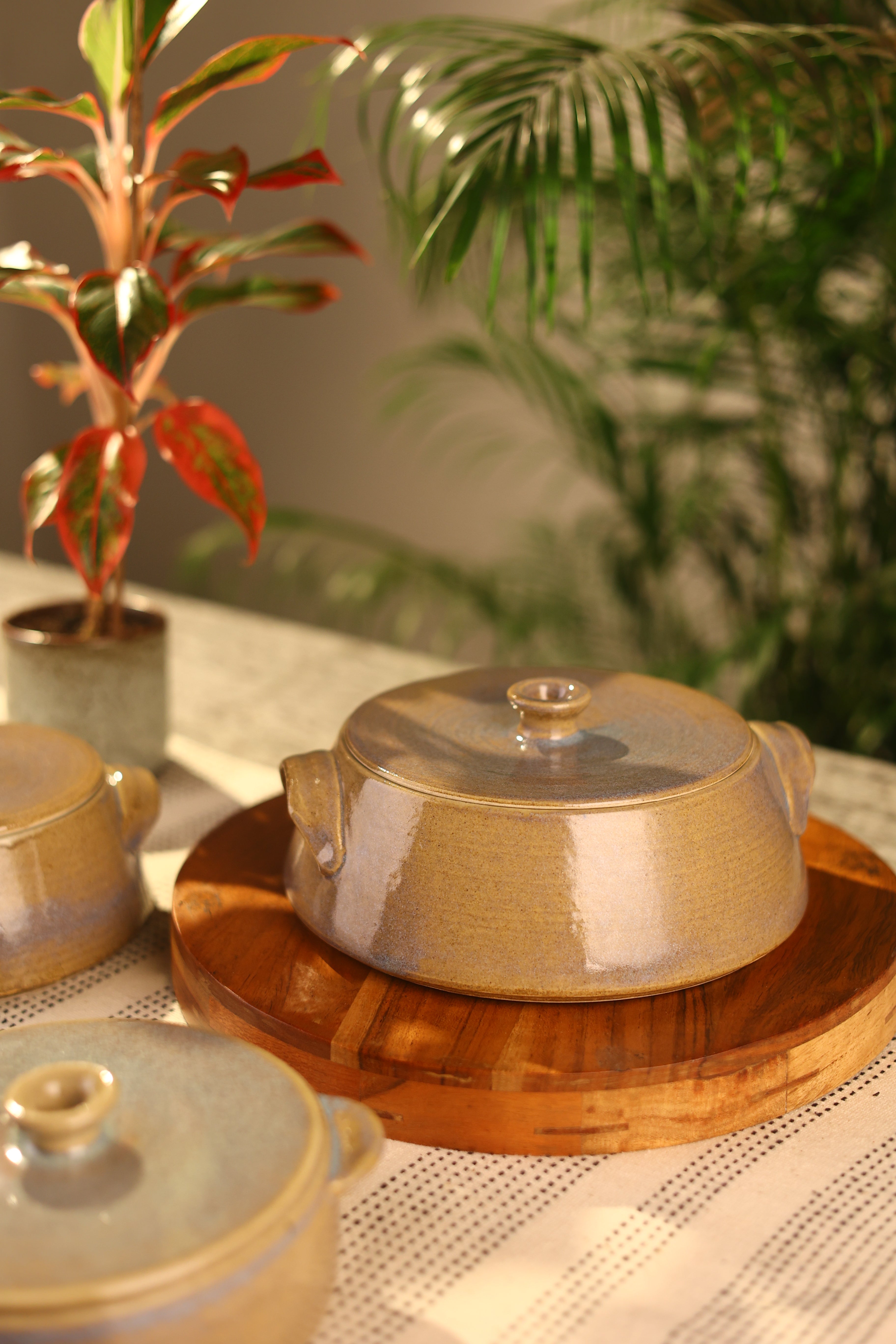 A mustard ceramic pot with a lid on a wooden surface artisanal serveware India,
handcrafted plates and bowls