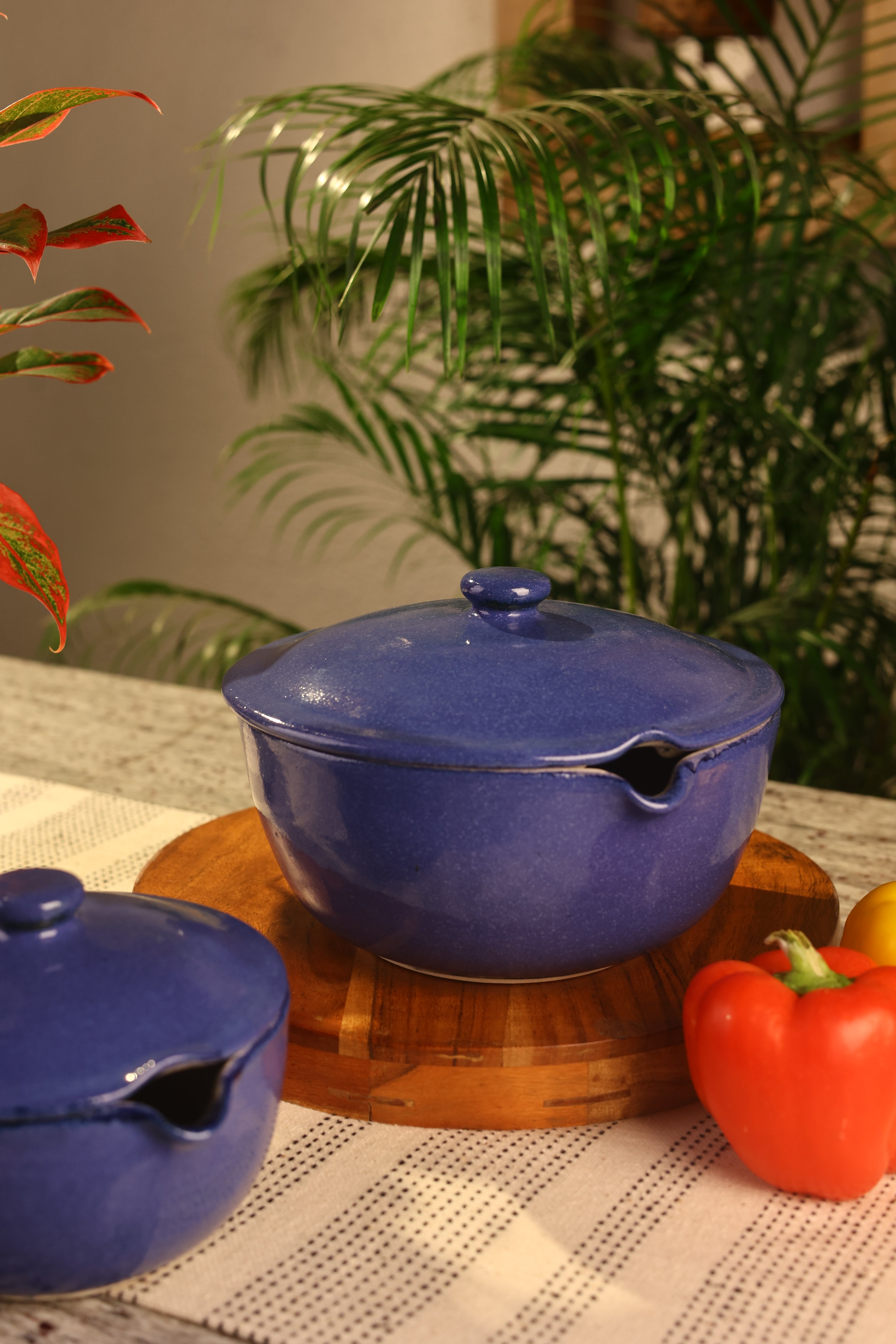 Blue ceramic pots with lids on a wooden surface. artisanal serveware India, handcrafted plates and bowls