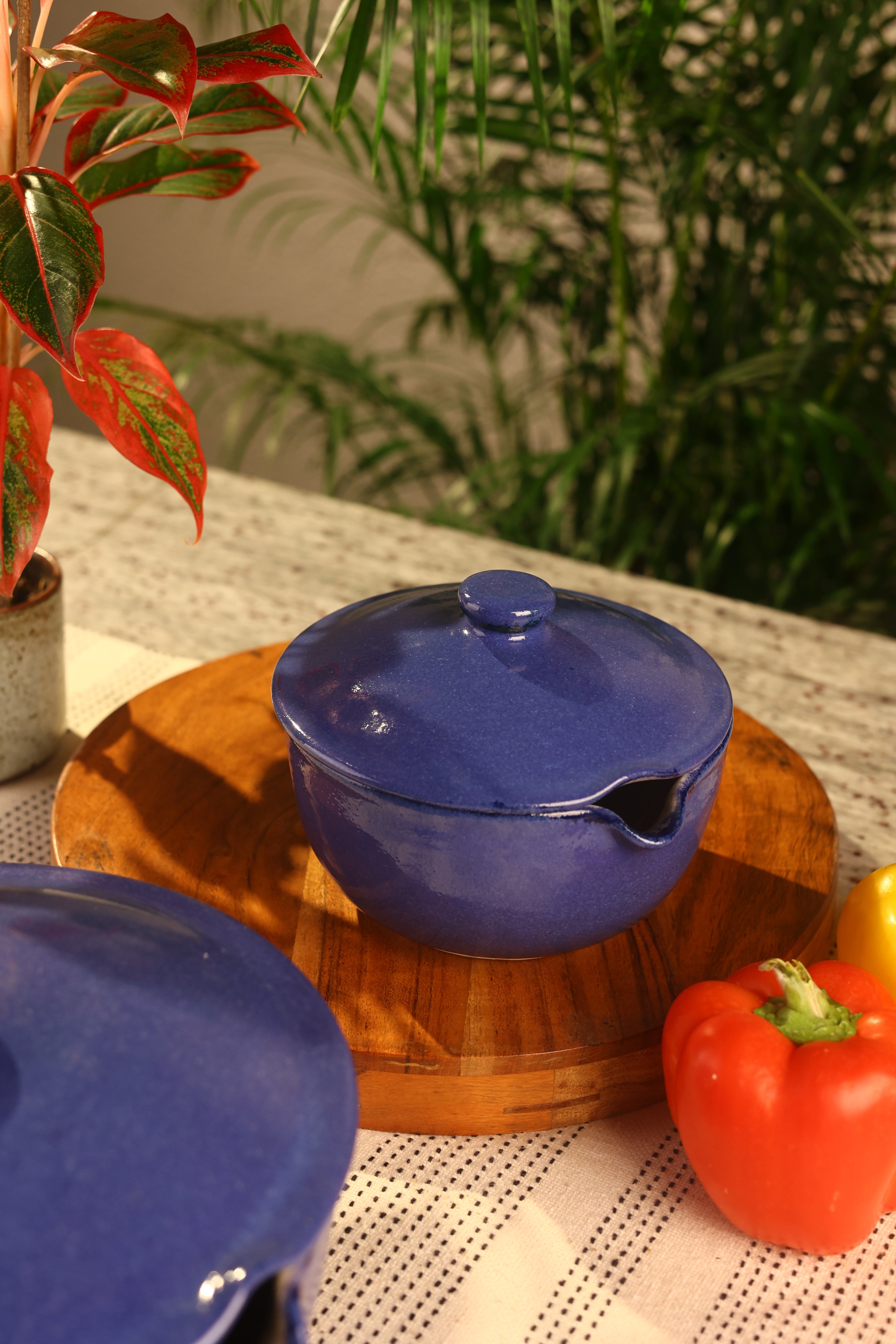A navy pot with a lid on a surface, artisanal serveware India, handcrafted plates and bowls