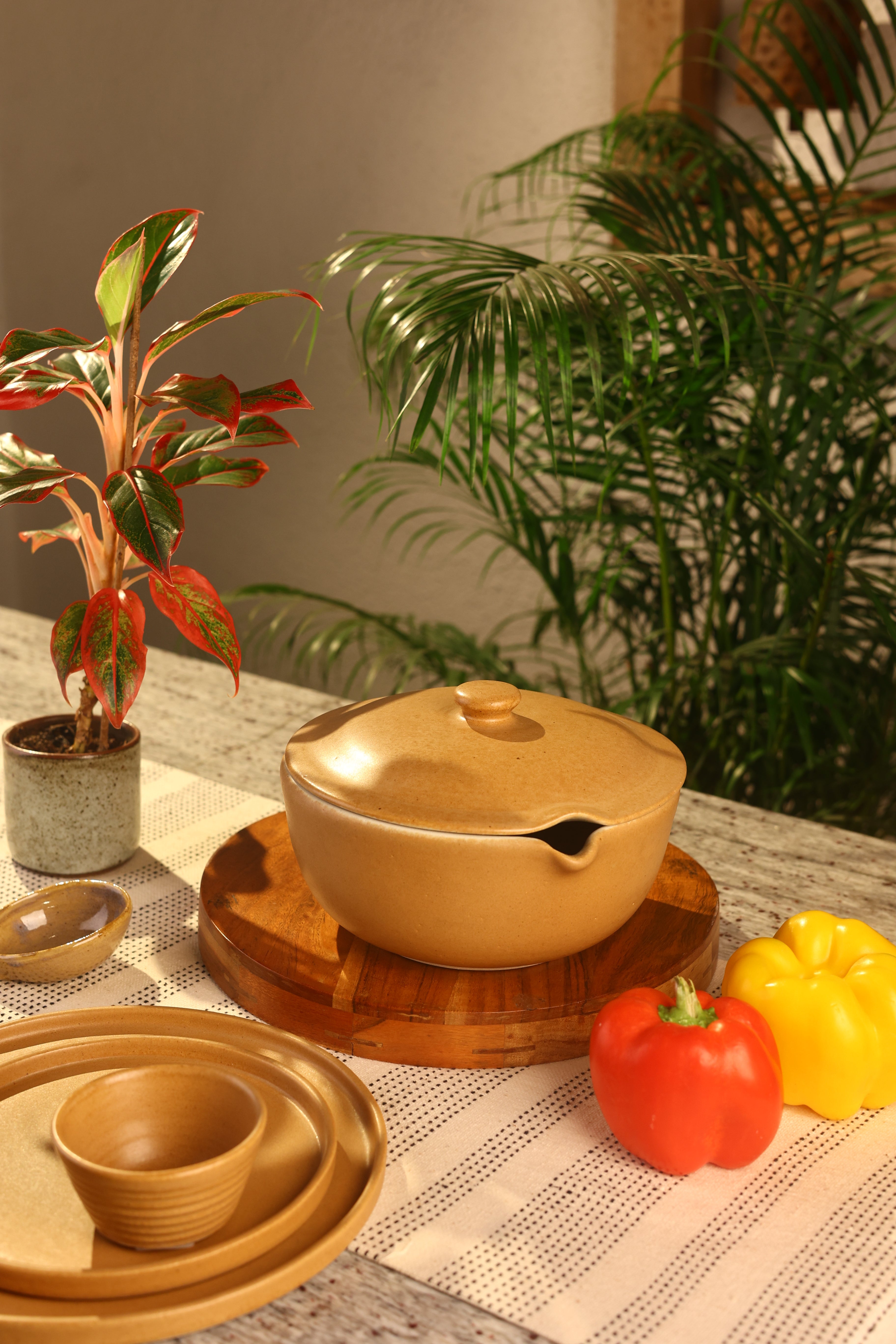 A mustard pot with lid on a wooden board, artisanal serveware India,
handcrafted plates and bowls
