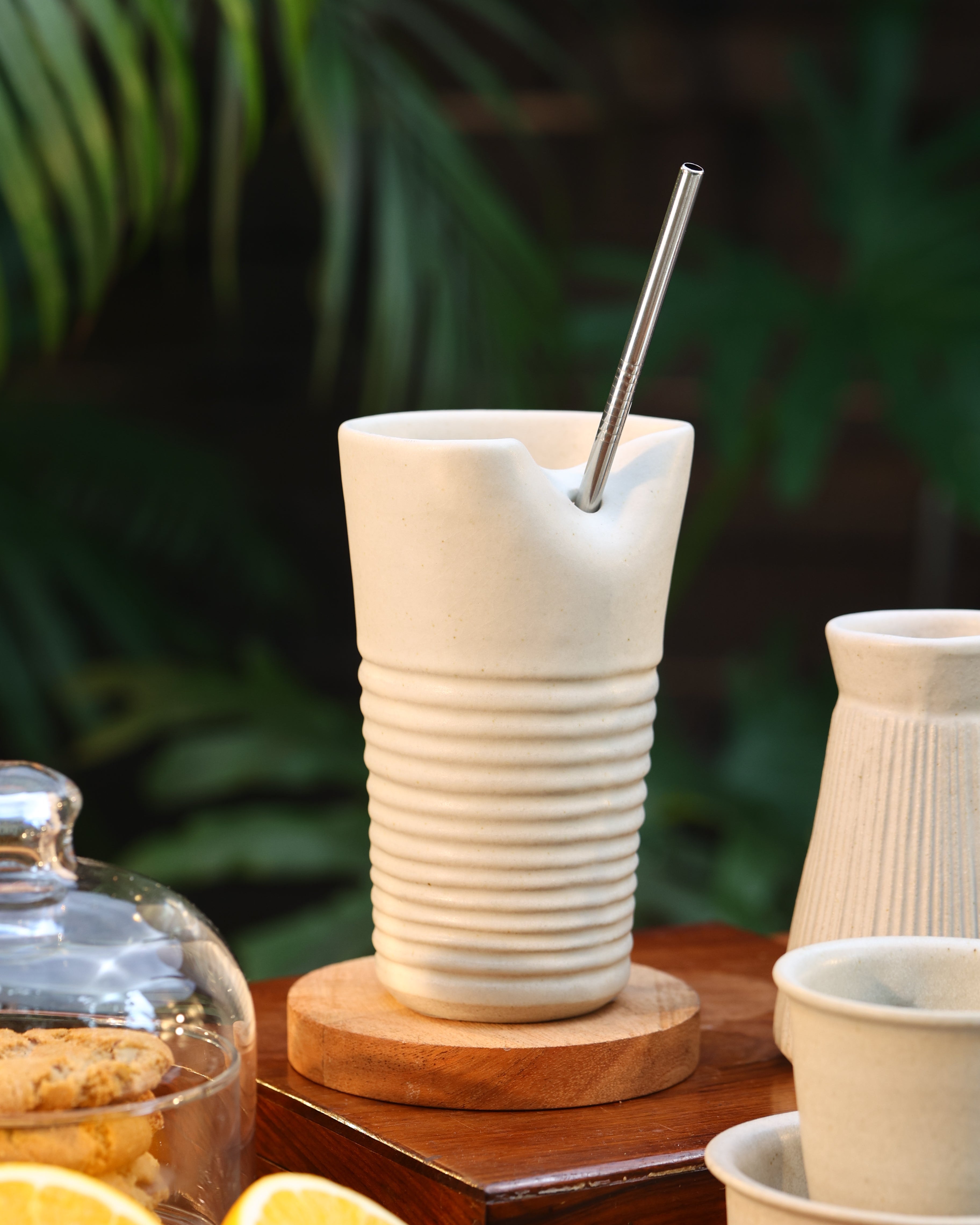 Close-up of a white tumbler with a metal straw, ceramic coffee mugs online,Indian pottery brands online