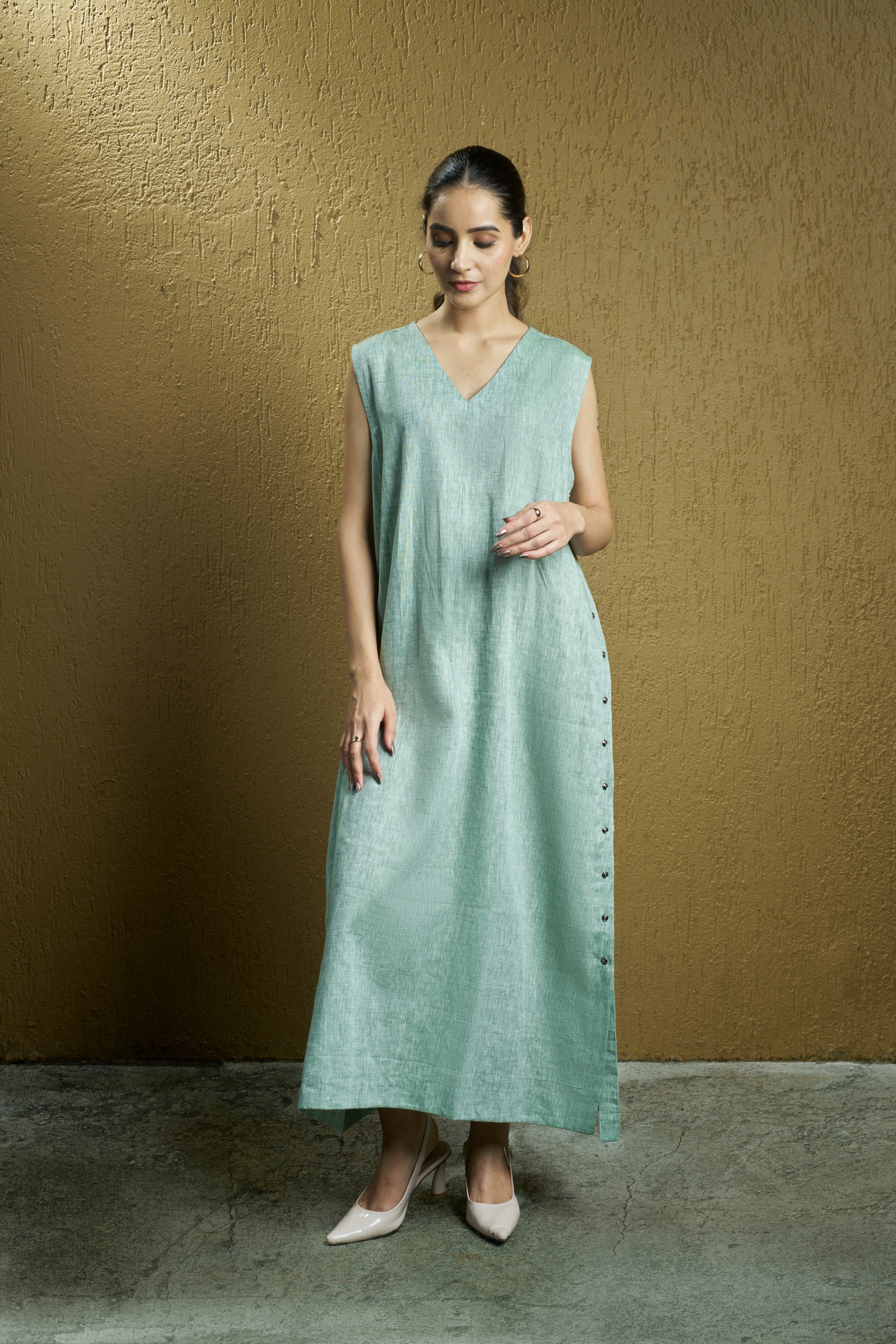 Woman wearing a mint green sleeveless dress. Womens resort wear mumbai, linen dresses shop online