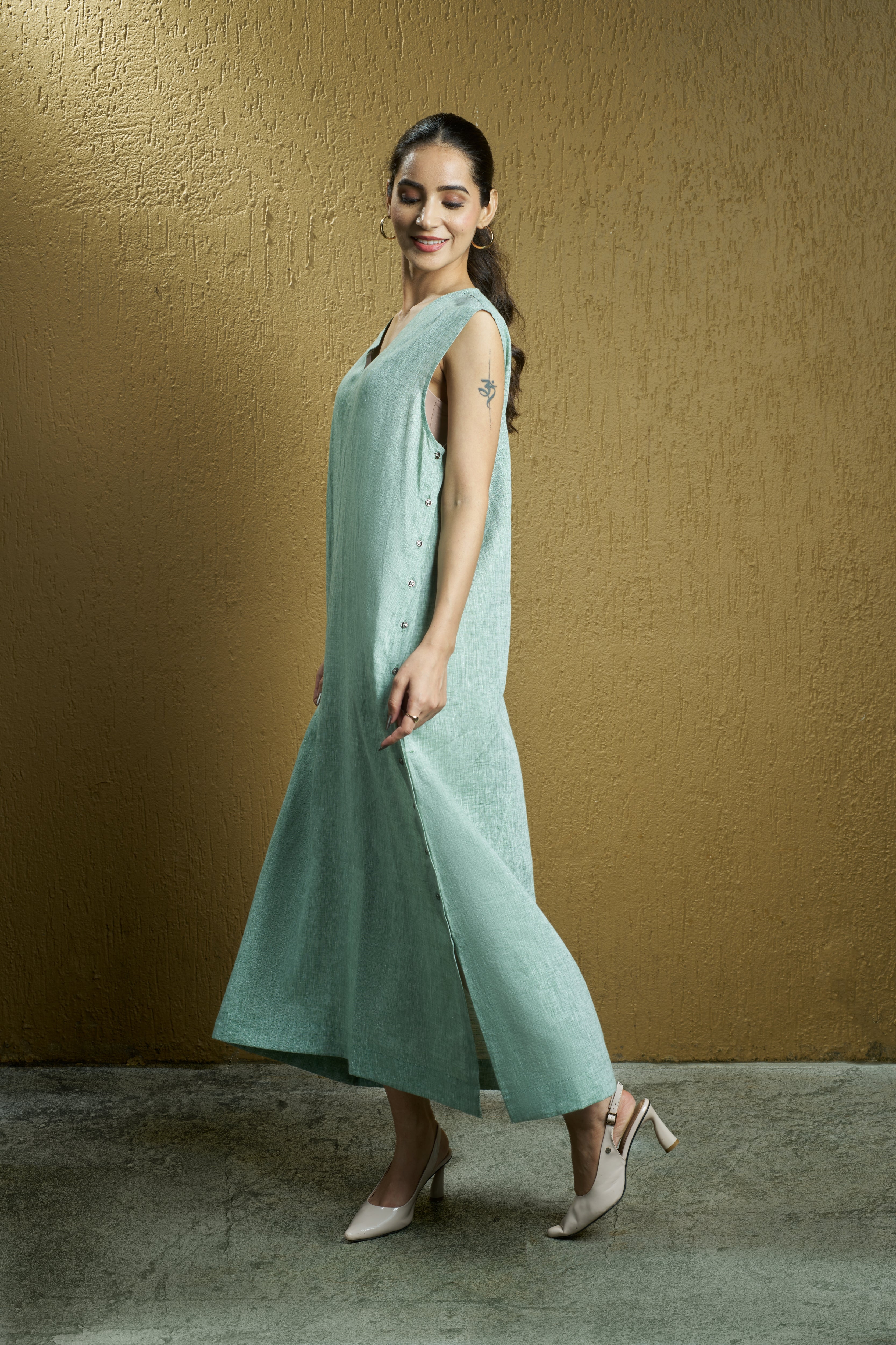 Woman wearing a mint green sleeveless dress. Womens resort wear mumbai, linen dresses shop online