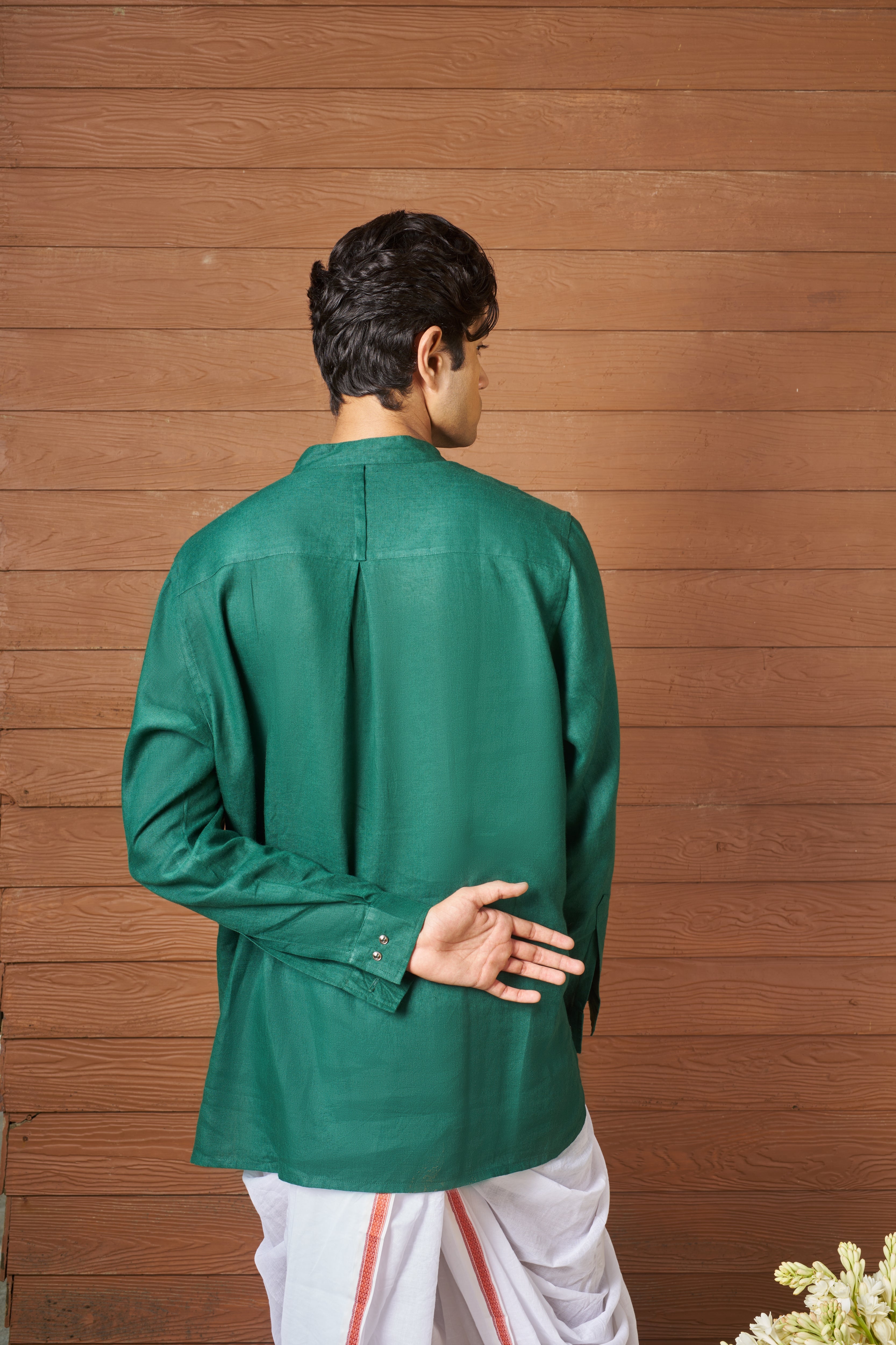 Man wearing a green shirt and white pants sustainable fashion brands for men, minimal menswear brands India