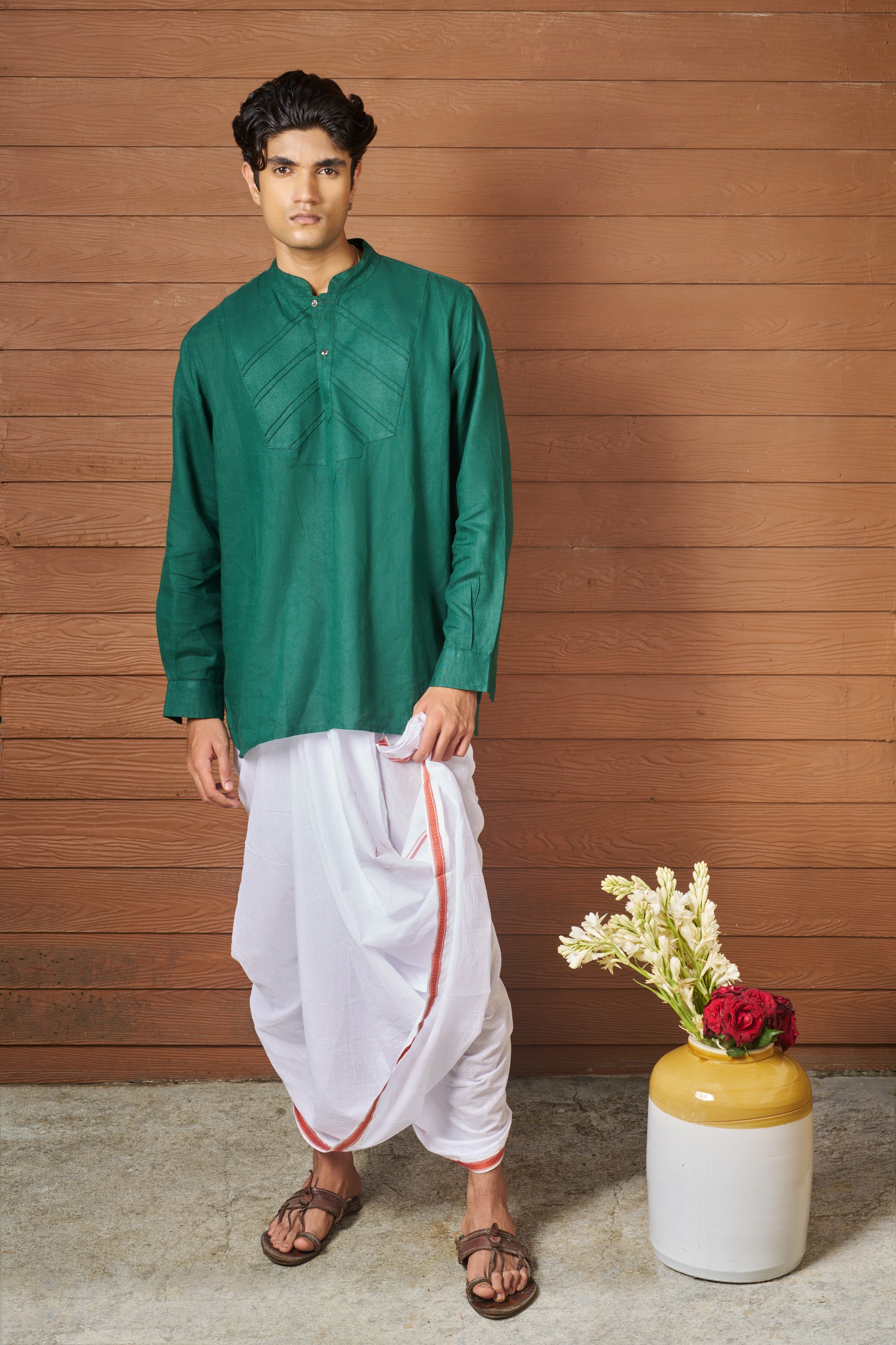 Man wearing a green shirt and white pants sustainable fashion brands for men, minimal menswear brands India