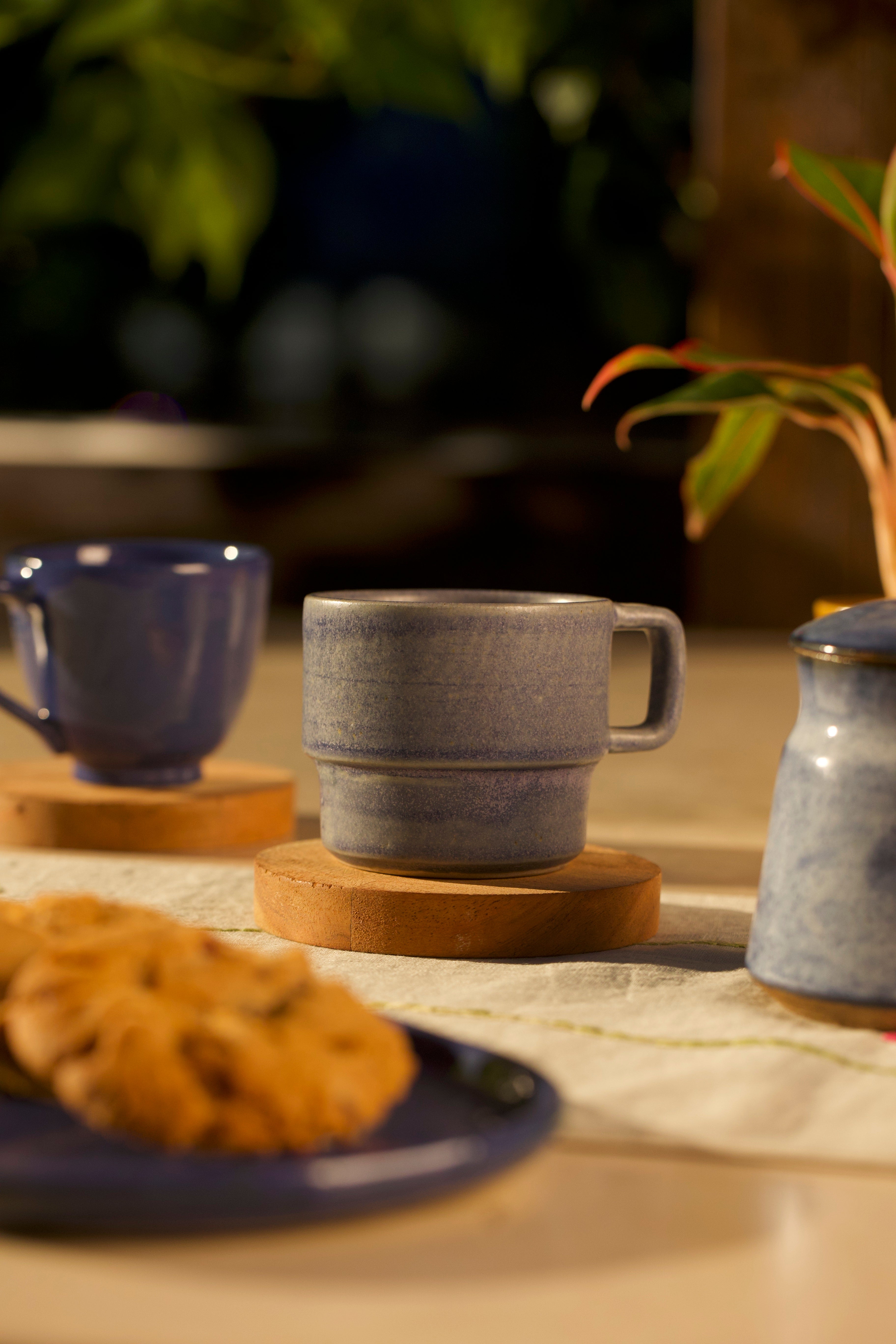 Navy ceramic mugs on a wooden table ceramic coffee mugs online, handmade ceramics India