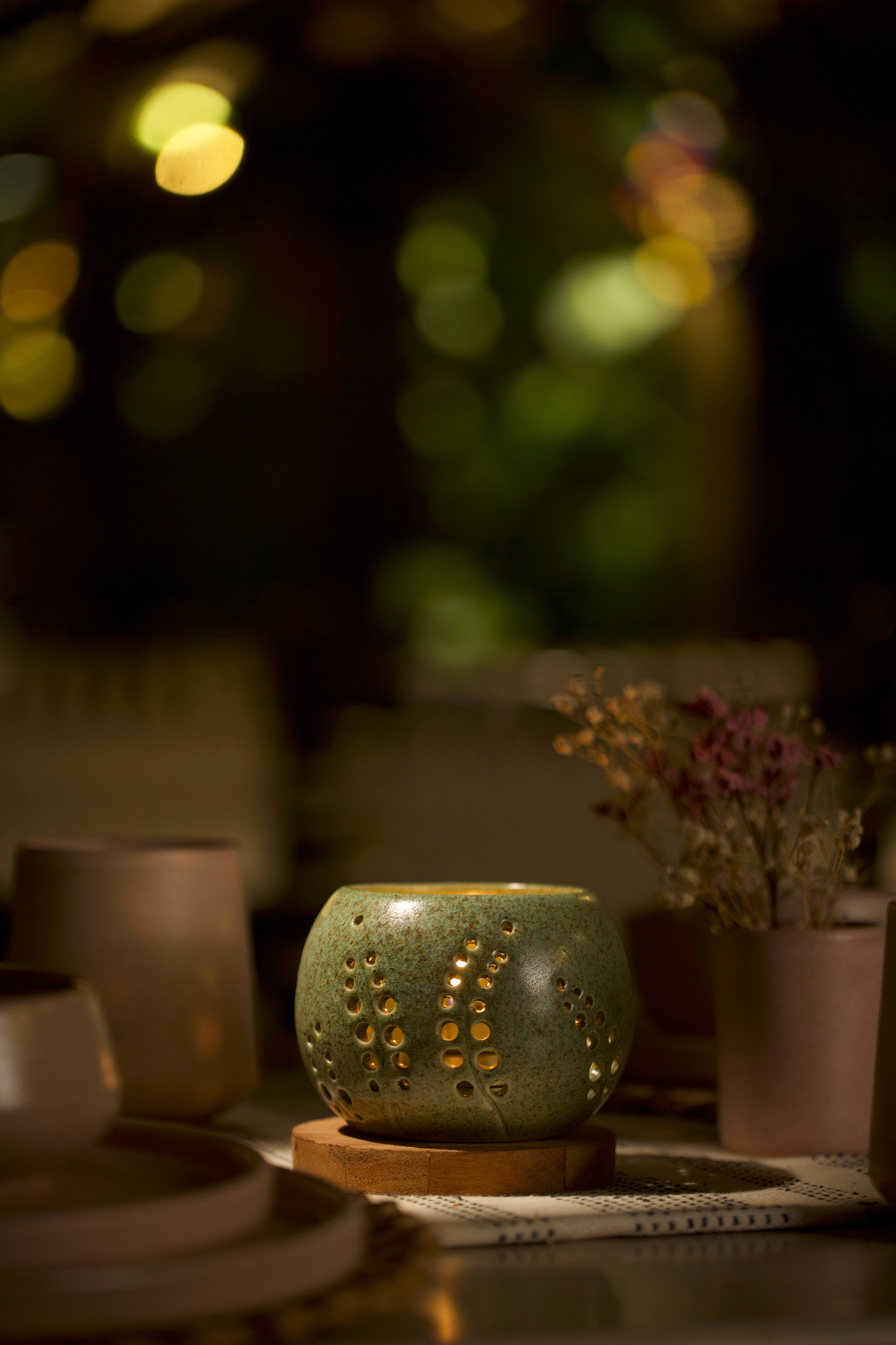 A green decorative ceramic pot with intricate design. Home decor shop online, artisanal home décor India