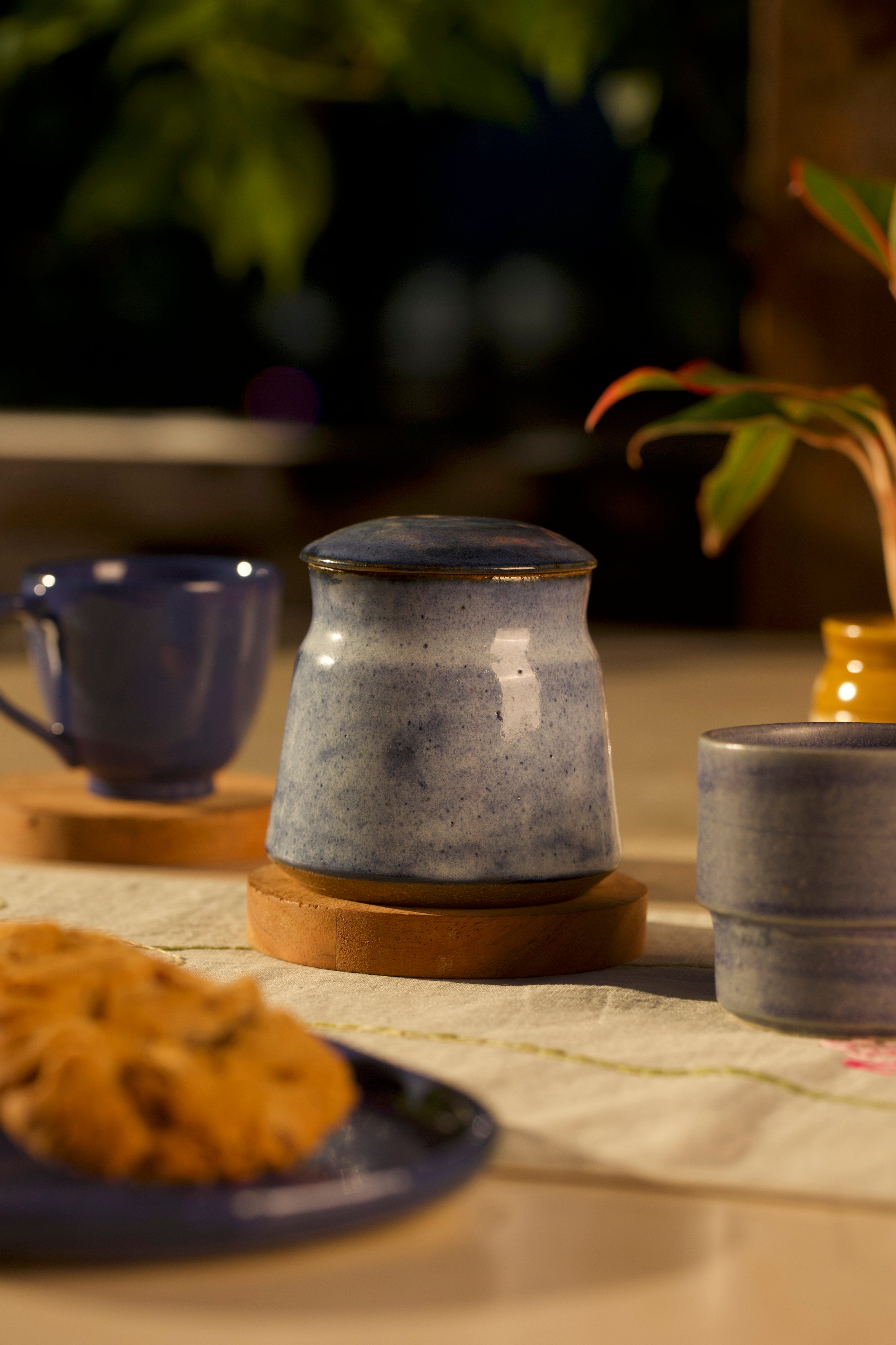 Ceramic teapot and cups on a table with cookies, Indian pottery brands online, handmade home essentials