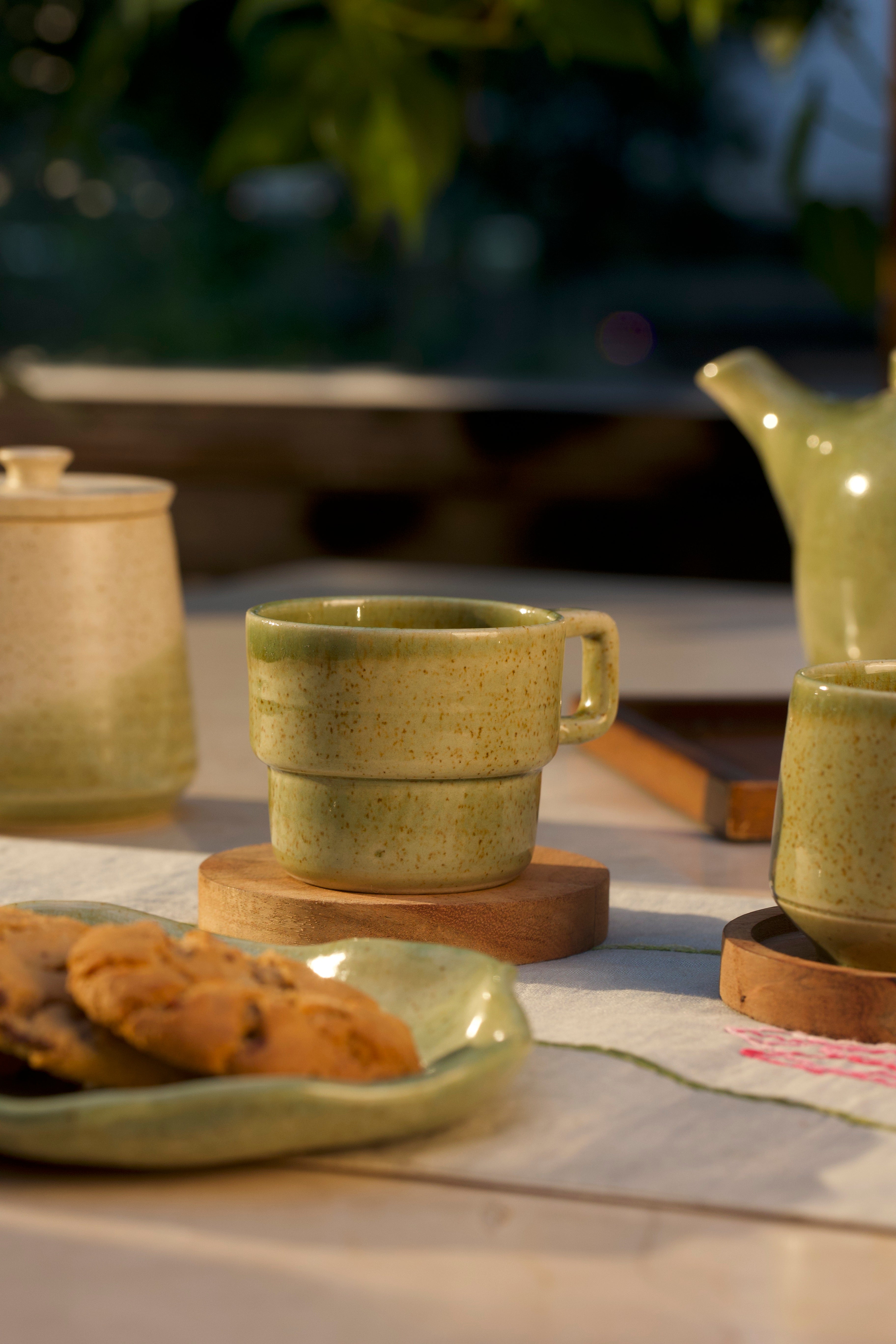 Green ceramic mug and teapot on a table ceramic coffee mugs online, handmade ceramics India