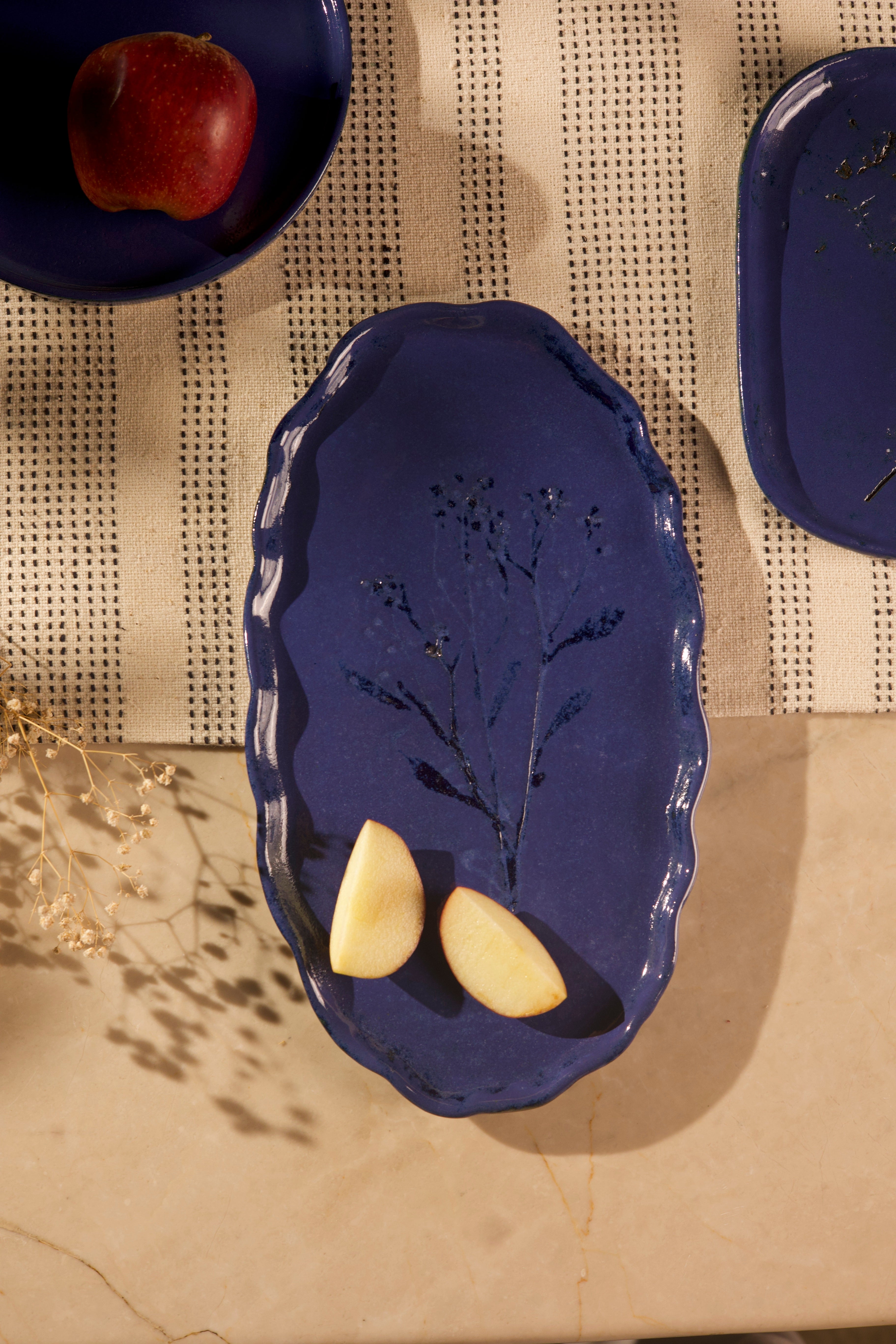 Blue ceramic dish with leaf design on a textured surface, handcrafted plates and bowls, dinner plates with natural glaze