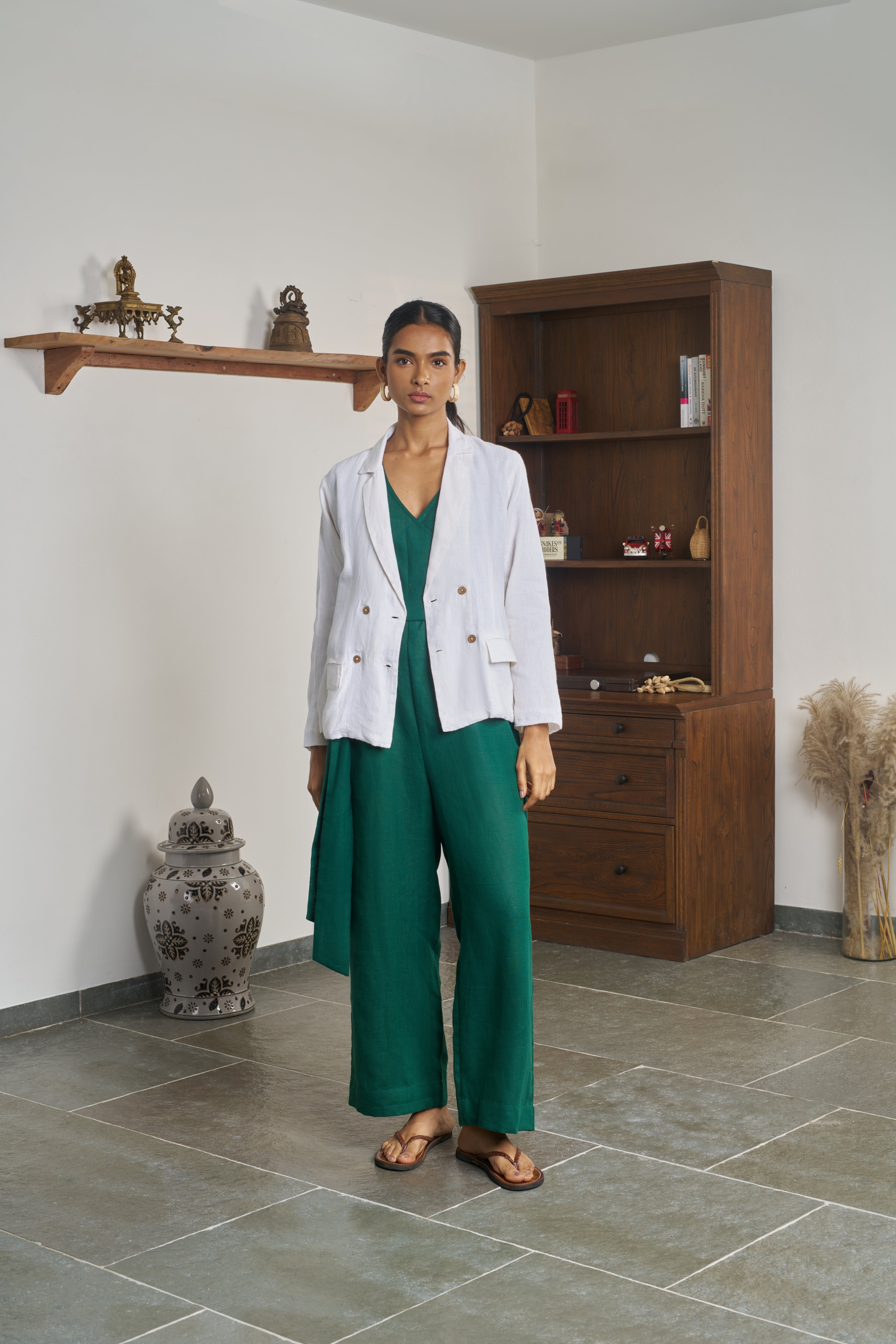 Woman in a white blazer and green outfit. ethical clothing brands for women, minimalist clothing brands India