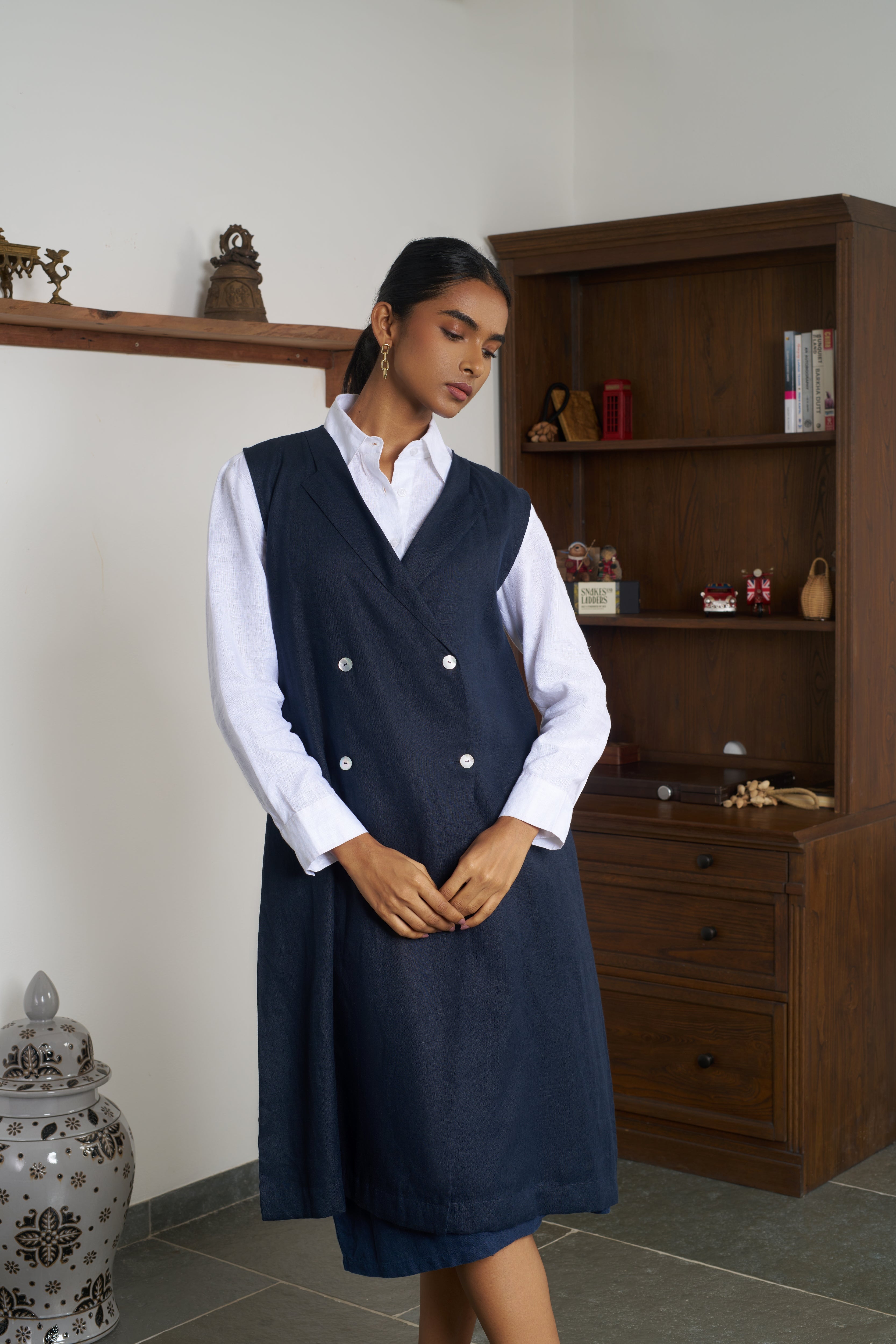 Woman wearing a navy blue vest over a white shirt.ethical clothing brands for women, slow fashion India