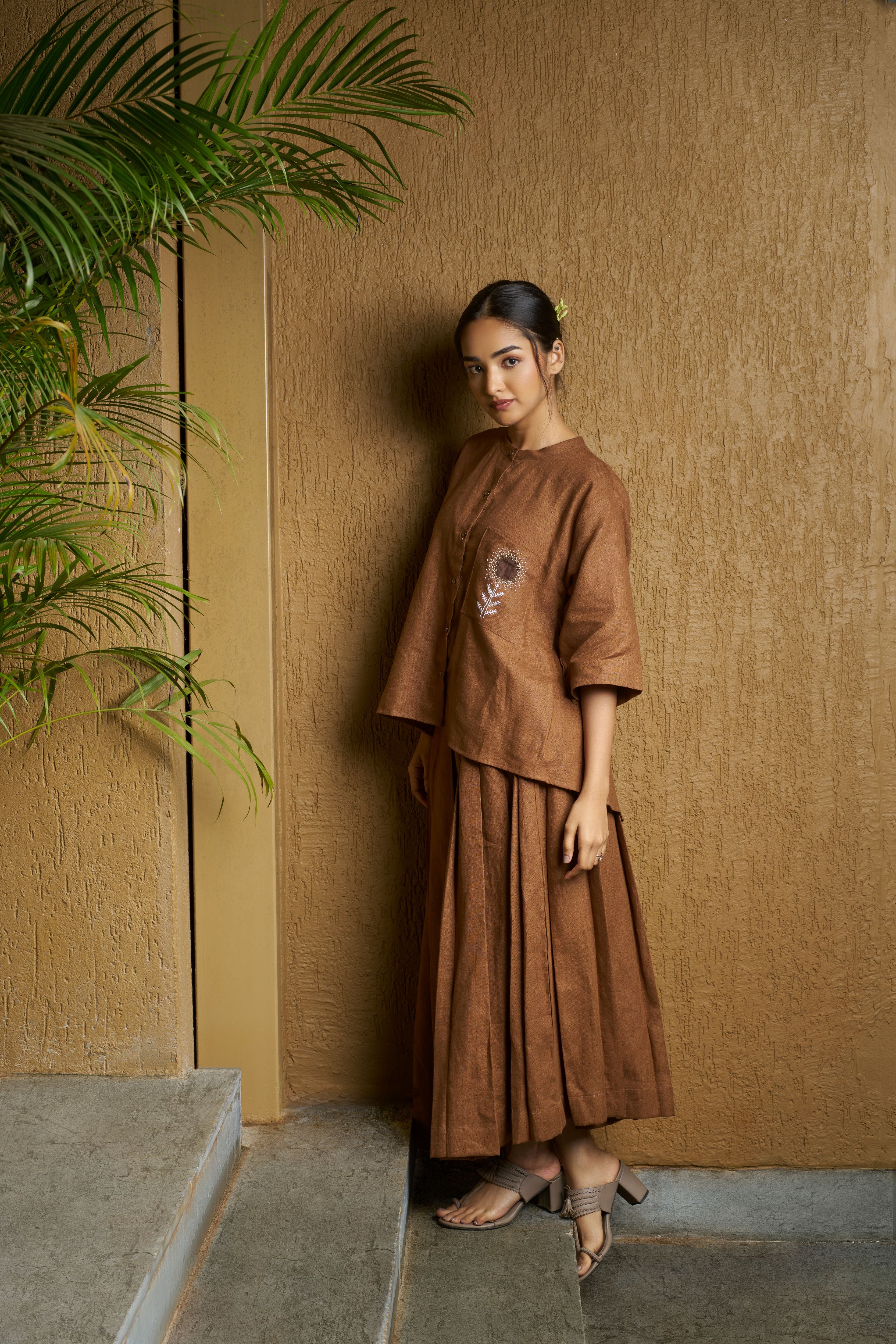 Woman in a brown blouse with embroidered white flower and brown skirt. timeless women’s fashion, 100% linen clothes India