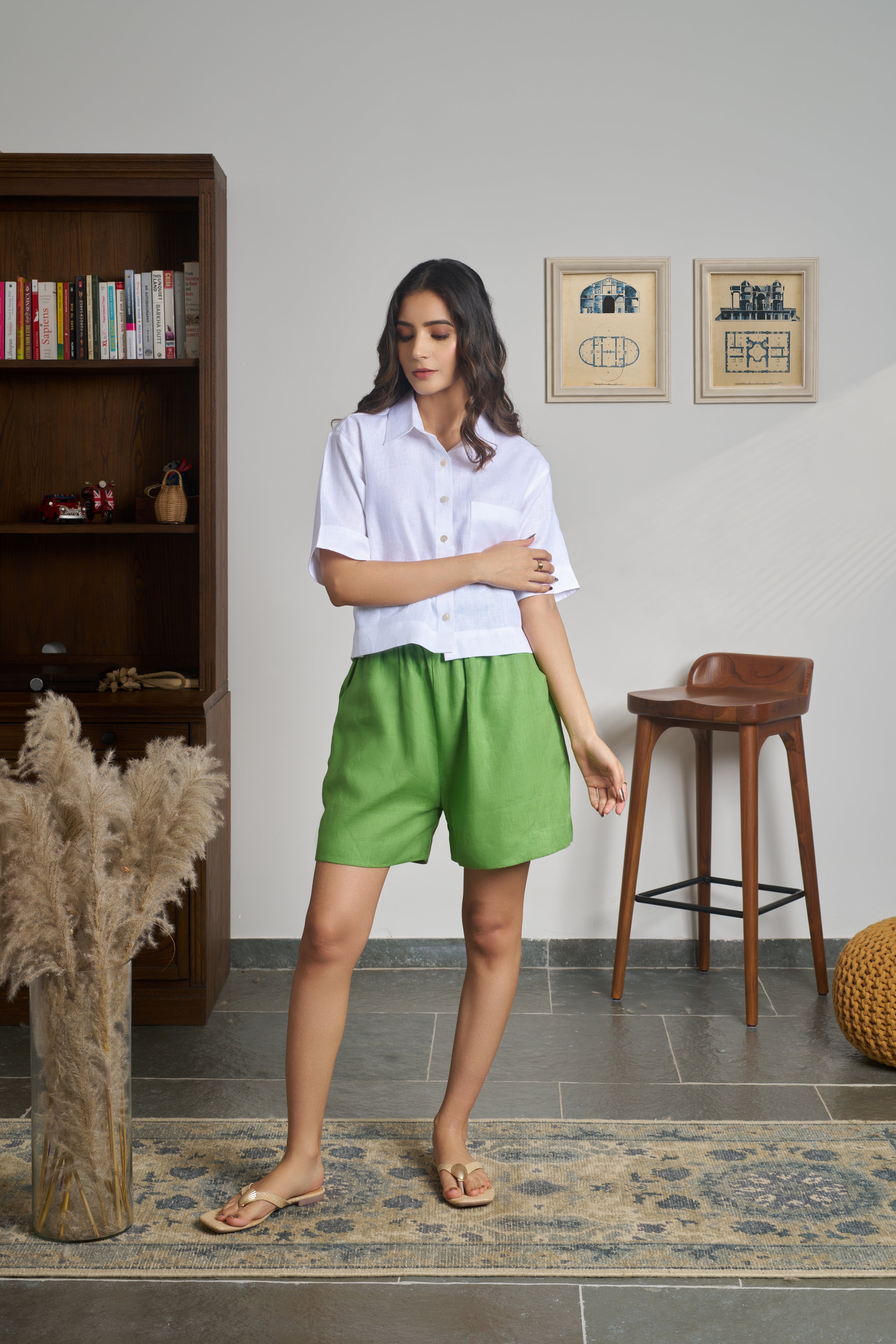 Woman wearing a white shirt and green shorts.