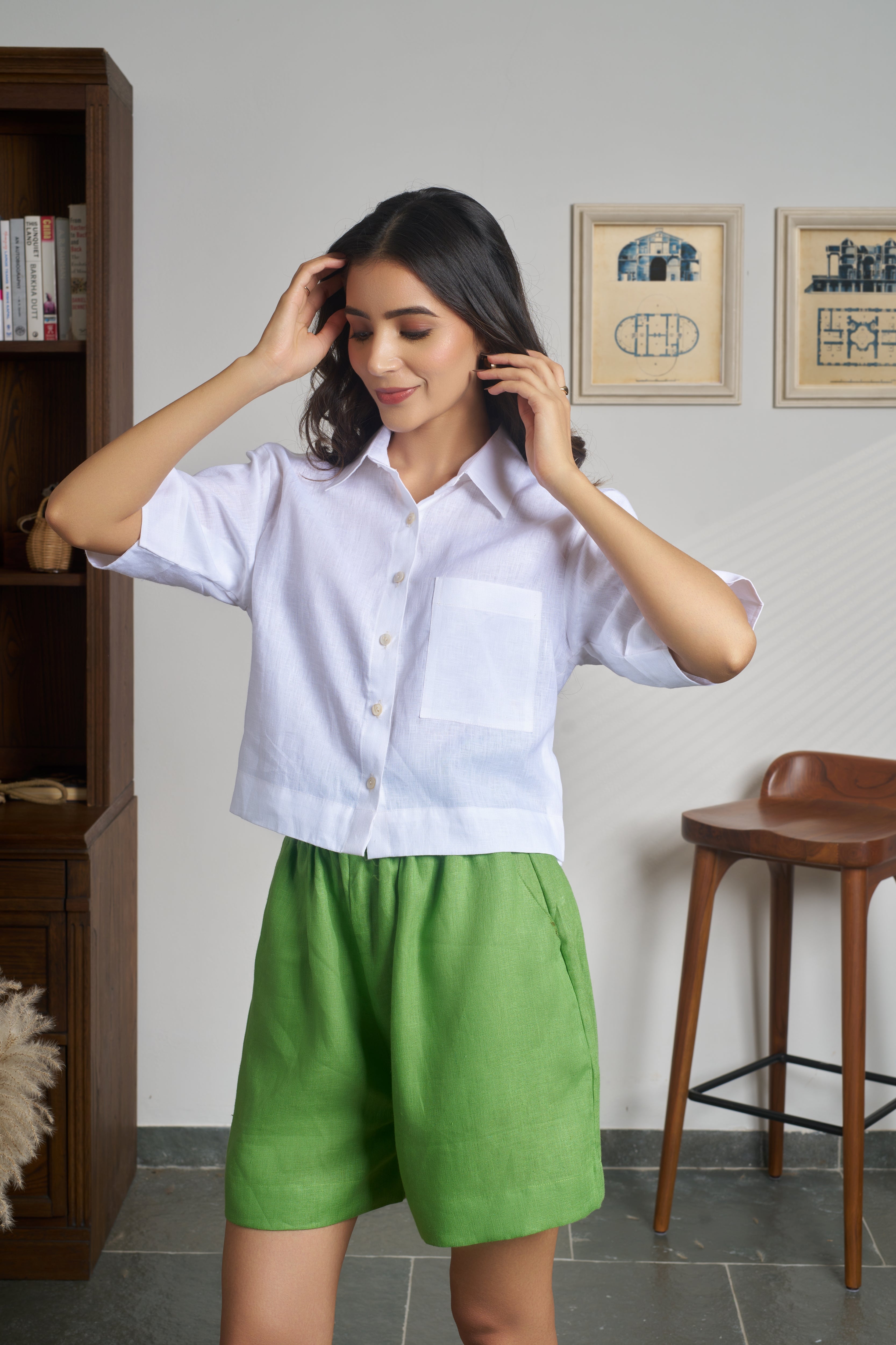 Woman wearing a white shirt and green shorts.