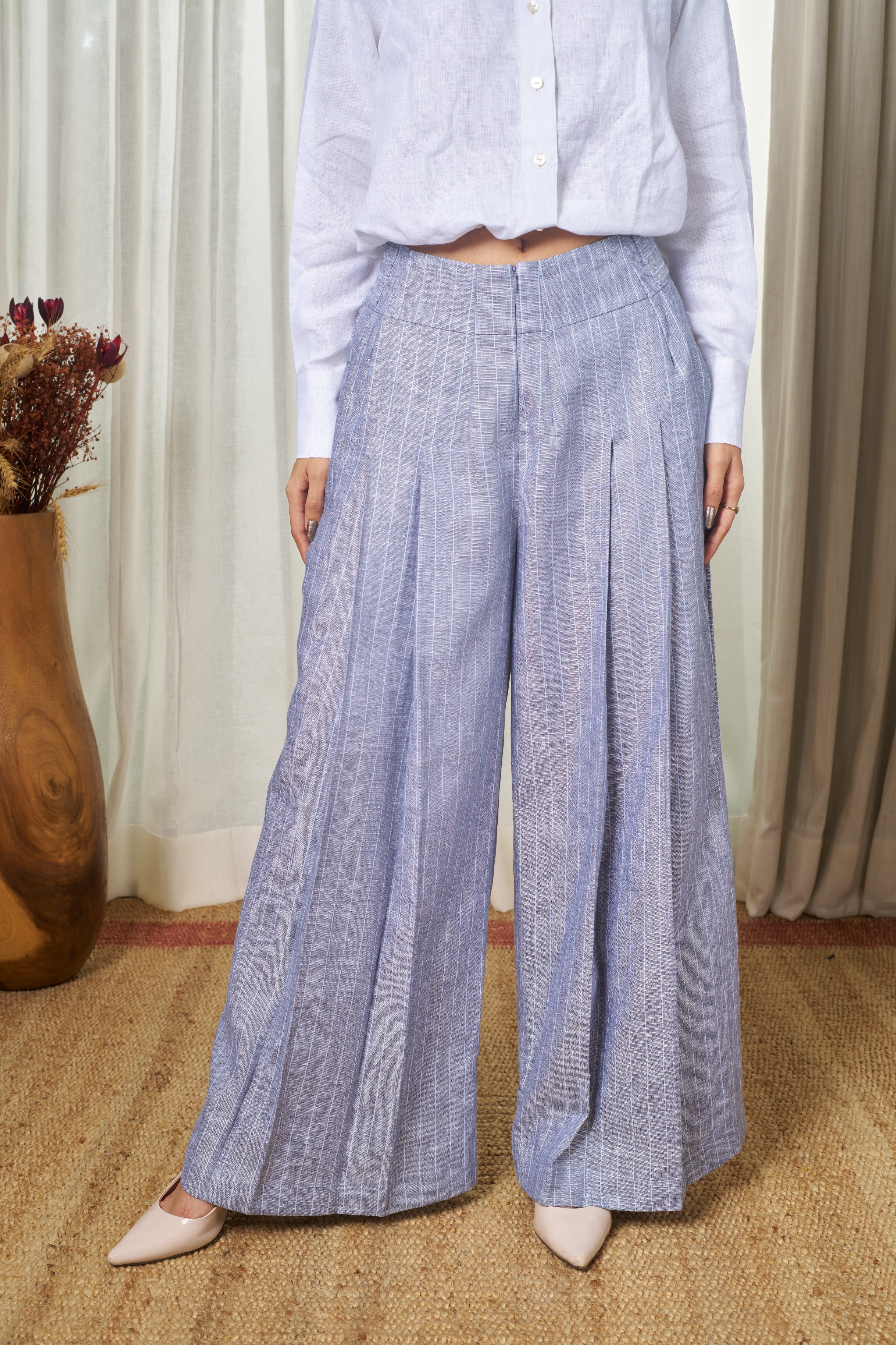 Woman wearing blue checkered pants and a light blue shirt.