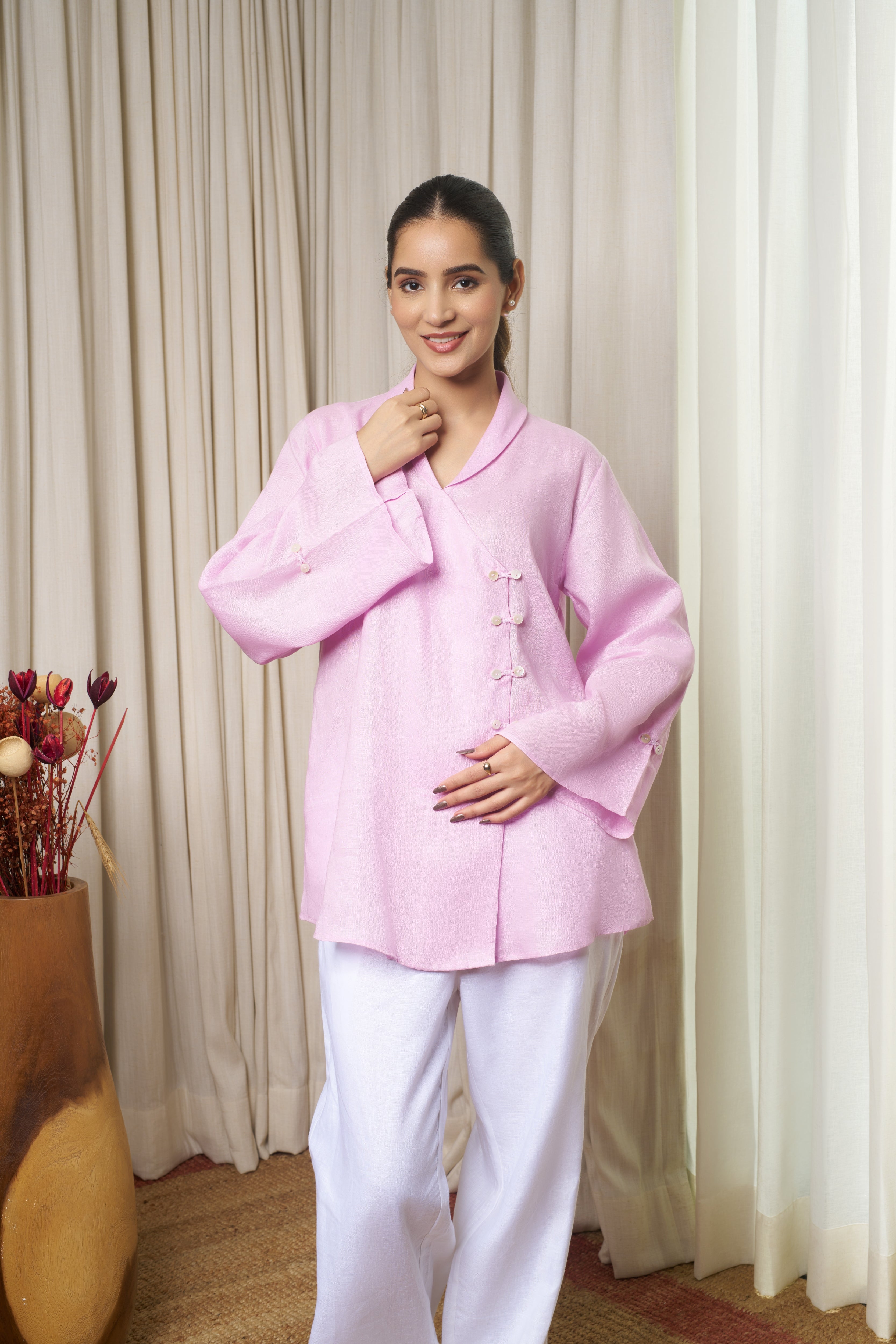 Woman wearing a pink shirt with white pants.Linen clothing mumbai,
sustainable women’s wear India