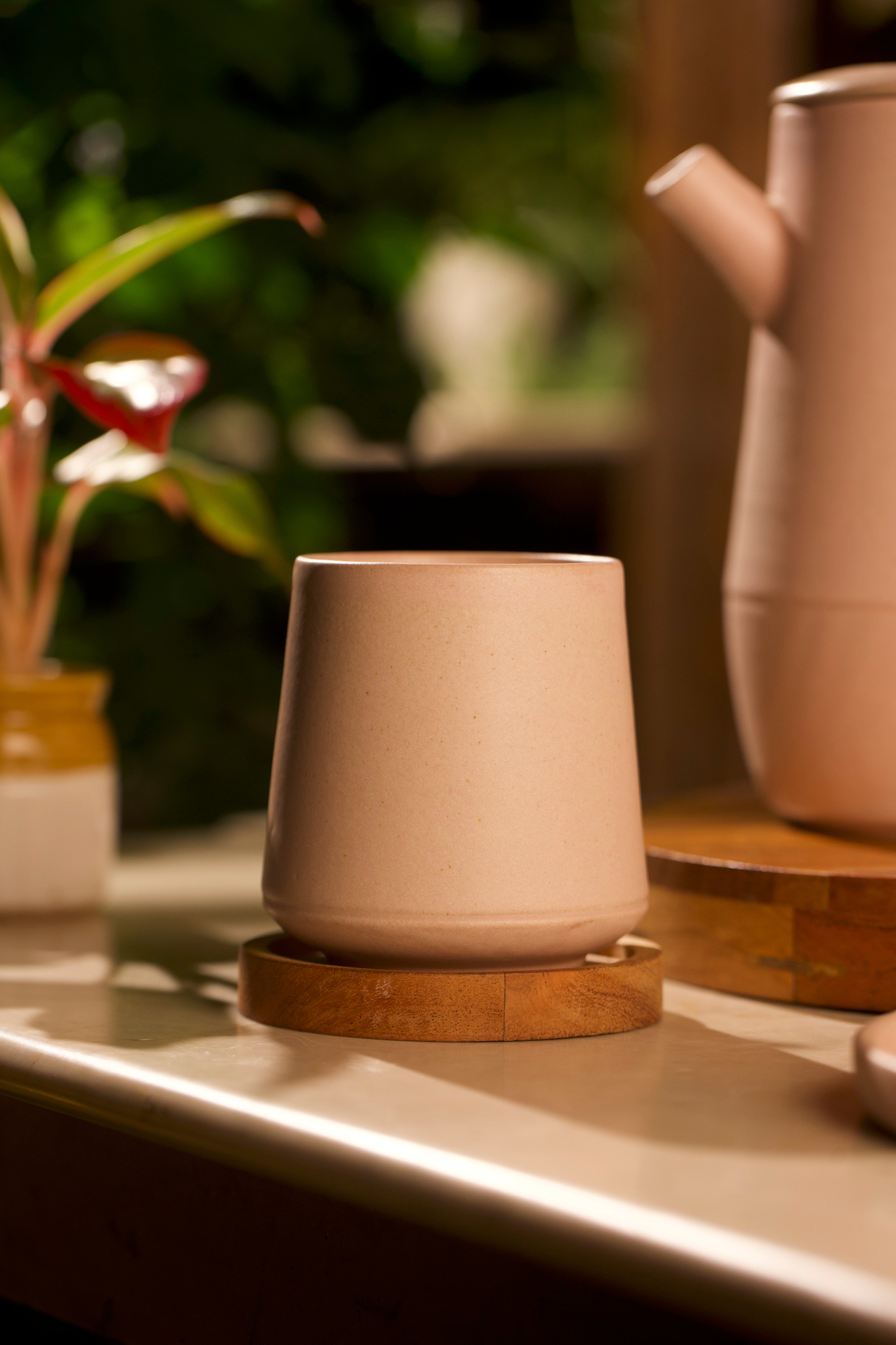 Ceramic cup with wooden coaster on a kitchen counter with blurred background, artisanal serveware India, handmade ceramics India