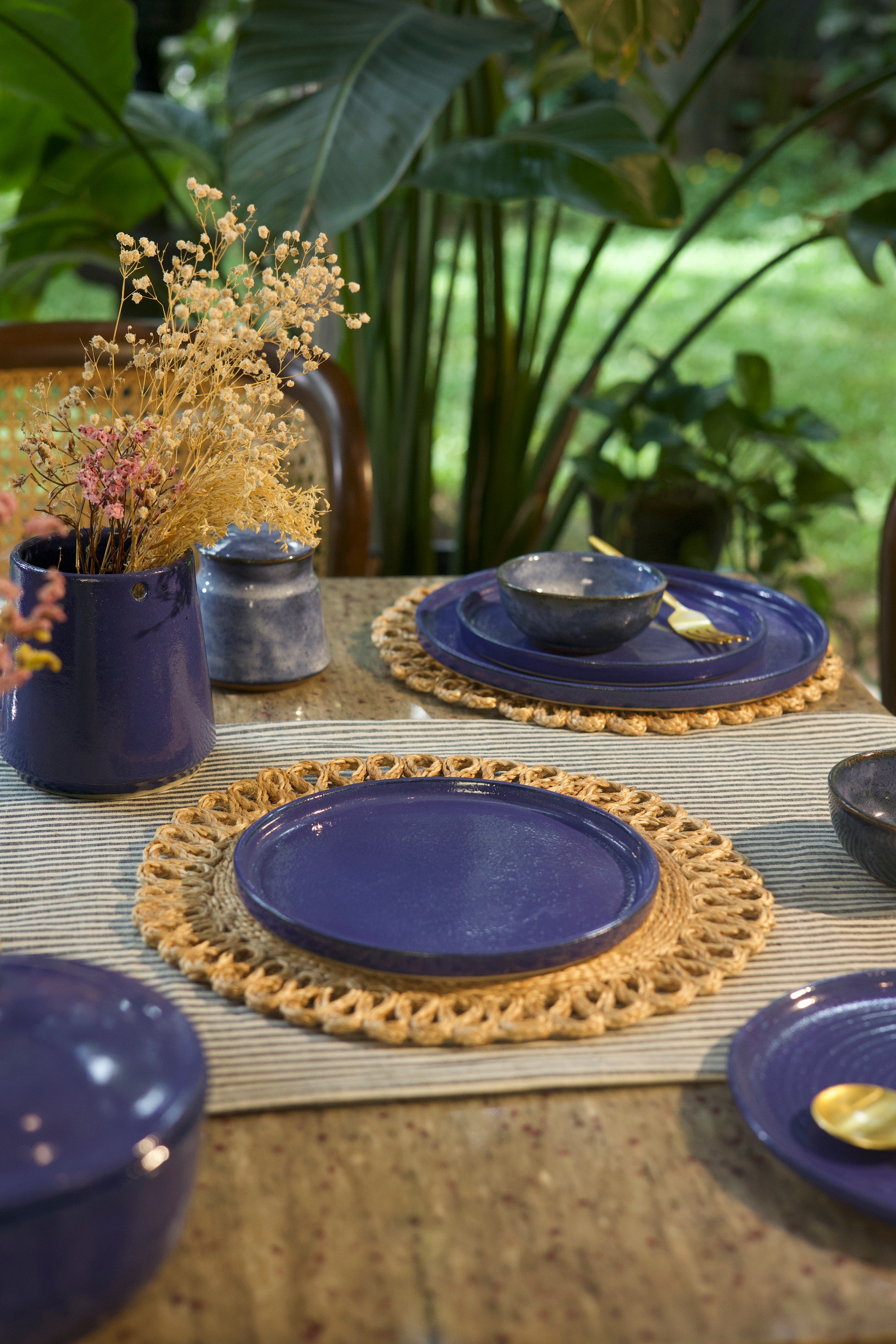 Navy blue plates on woven placemats handmade dinnerware India, handcrafted plates and bowls