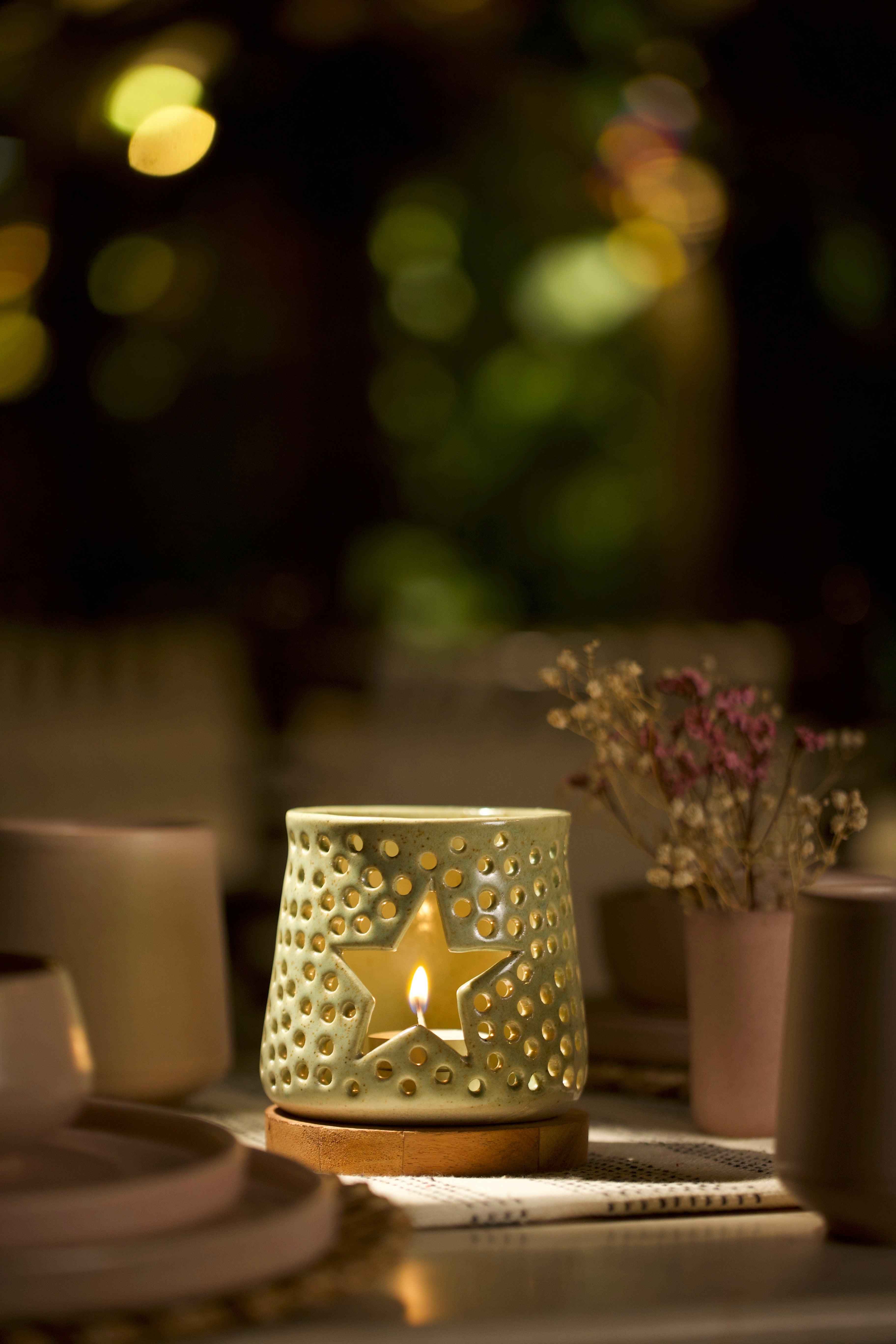 A green decorative ceramic lantern with intricate design. ceramic home décor online, minimalist home décor India