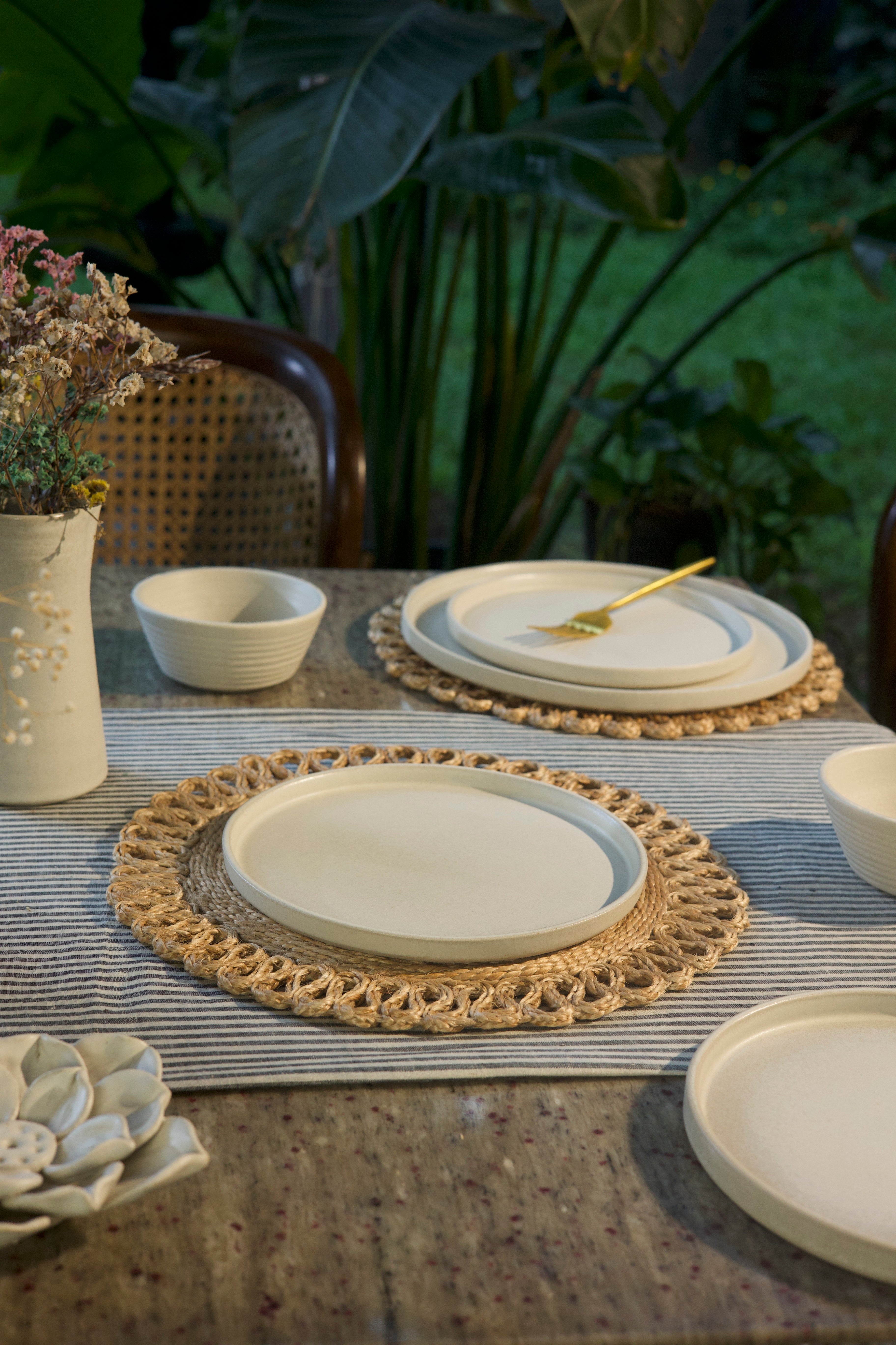 White dining plates, bowls, and a placemat, handmade dinnerware India, handcrafted plates and bowls