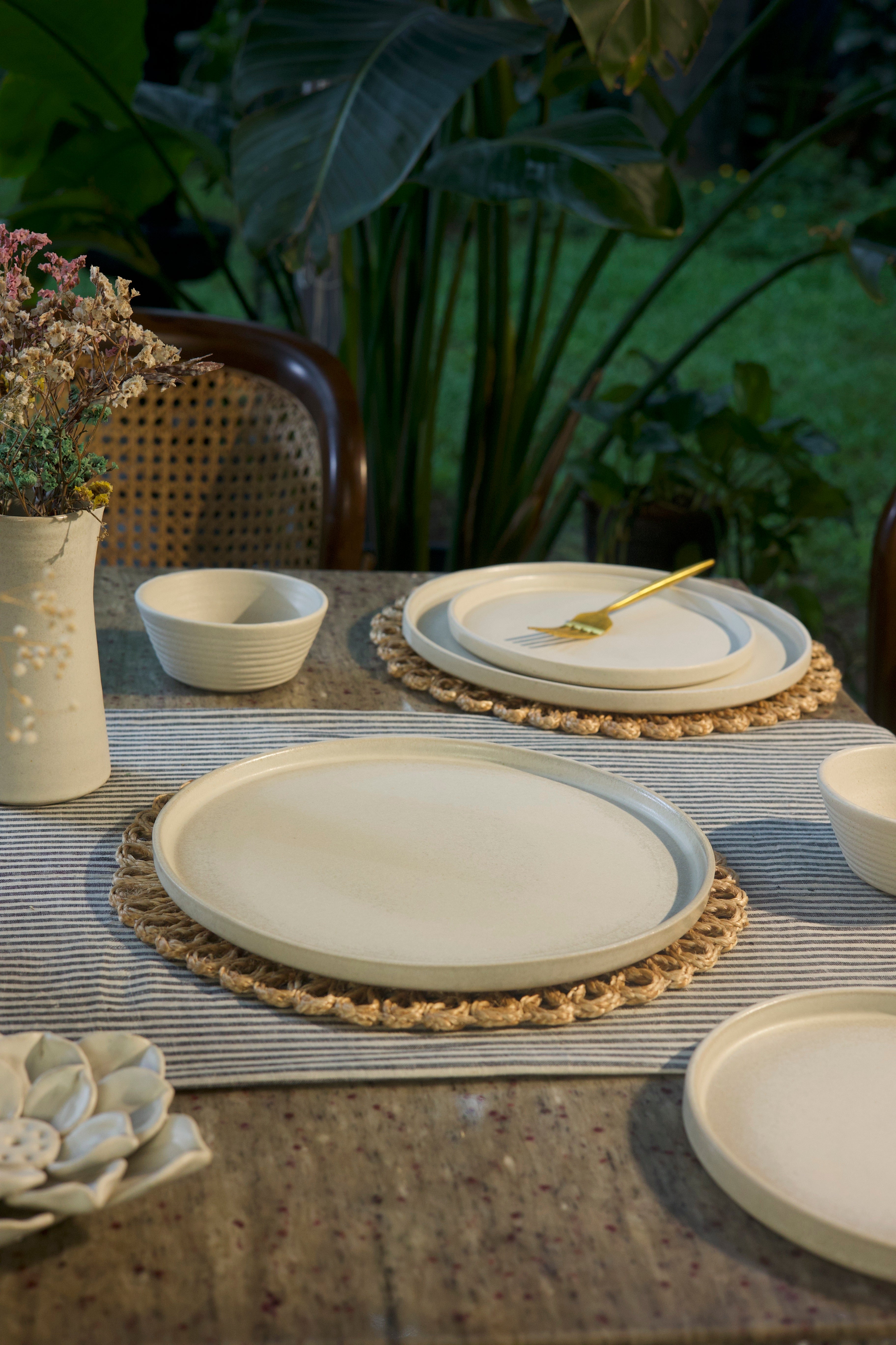 White ceramic plates, bowls, and a placemat, handmade dinnerware India, handcrafted plates and bowls