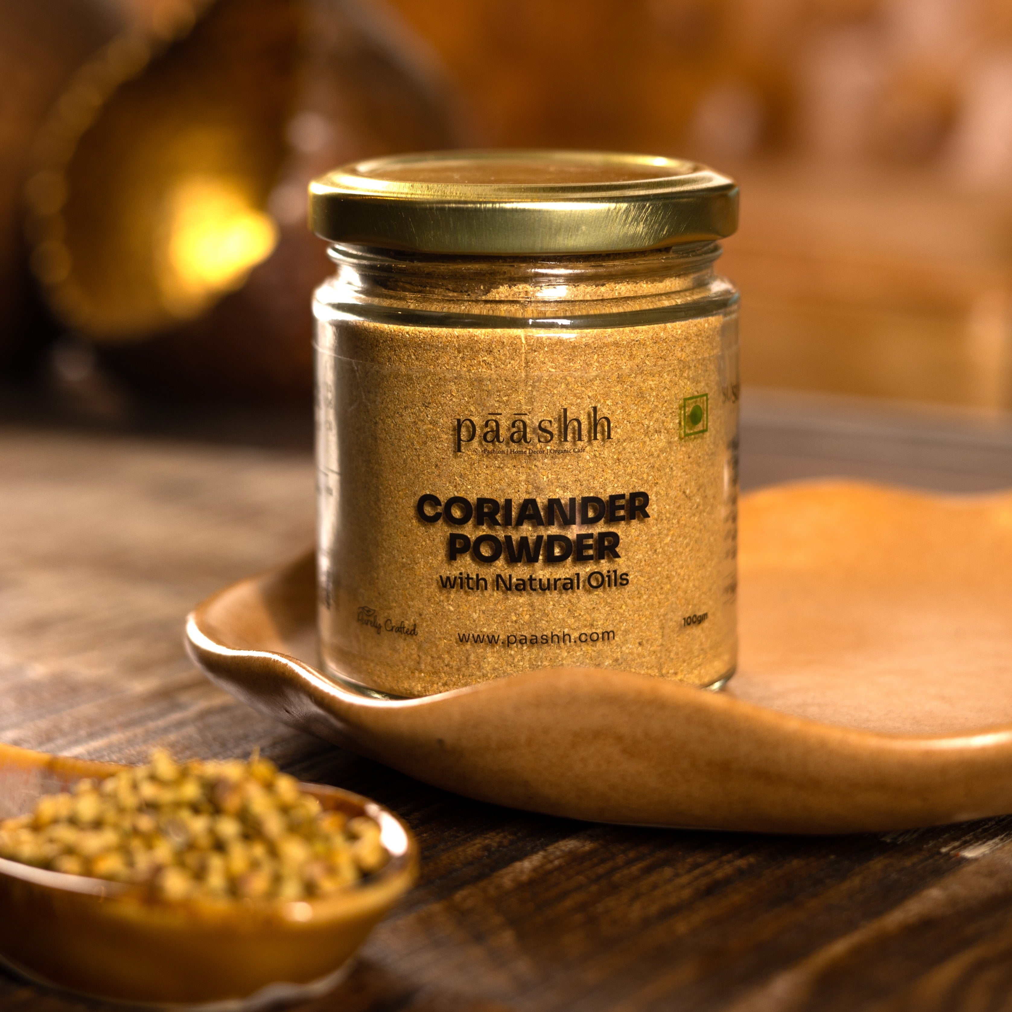 Jar of paashh coriander powder on a wooden surface, organic spices India,  organic kitchen ingredients