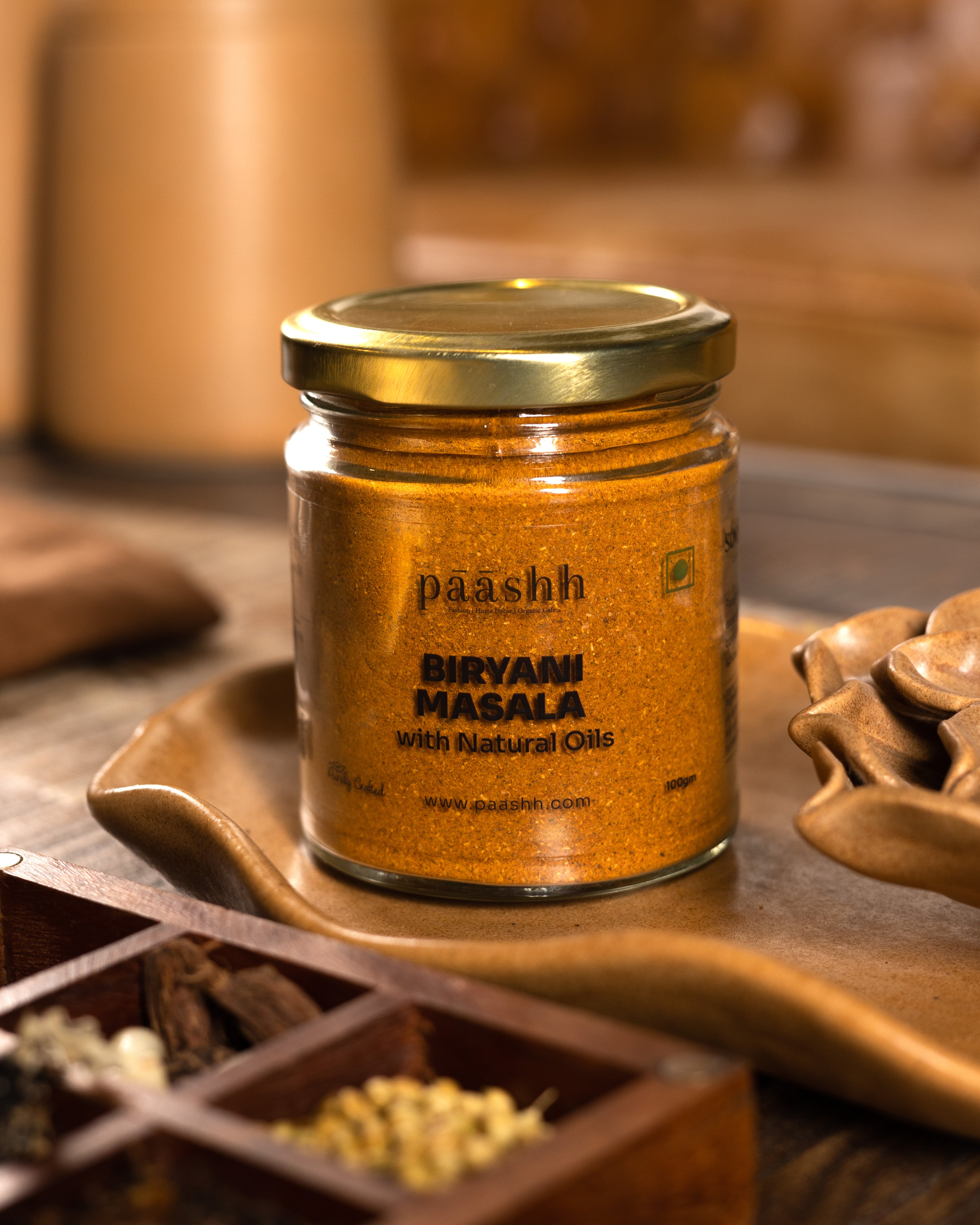 Jar of paashh Biryani Masala on a wooden surface, handcrafted masala blends India,  organic kitchen ingredients