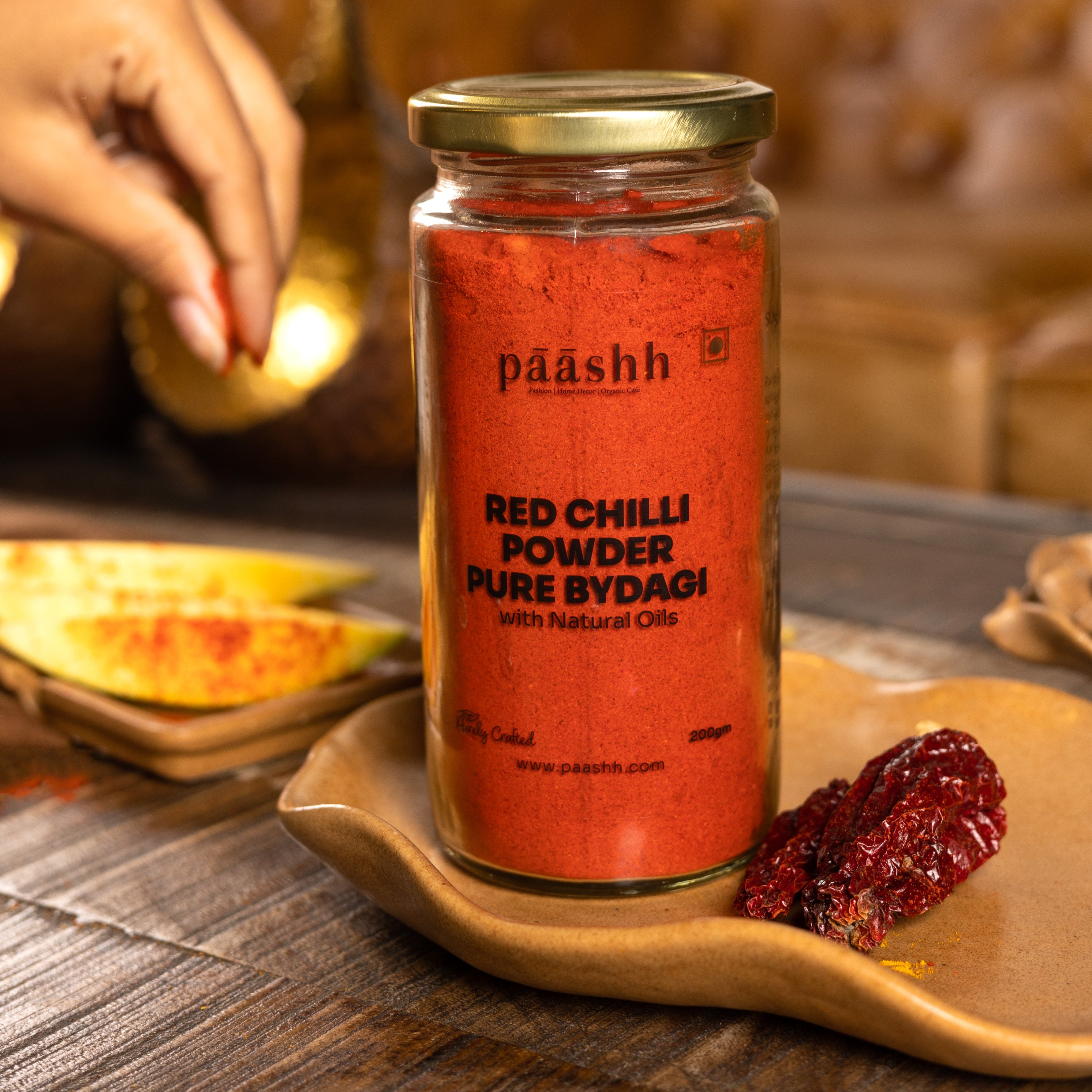 Jar of paashh Red Chilli Powder Pure bydagi on a wooden surface, organic spices India, organic kitchen ingredients