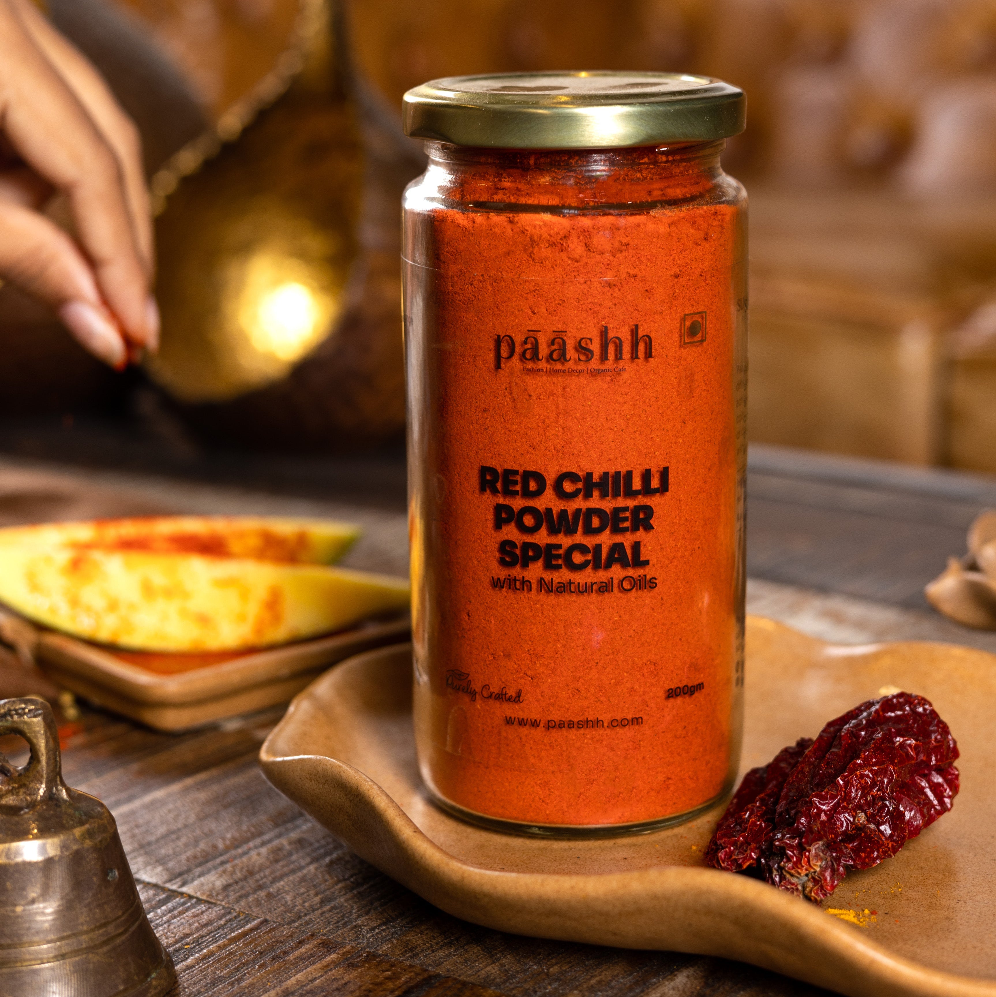 Jar of paashh red chilli powder special on a wooden tray, organic spices India, organic kitchen ingredients