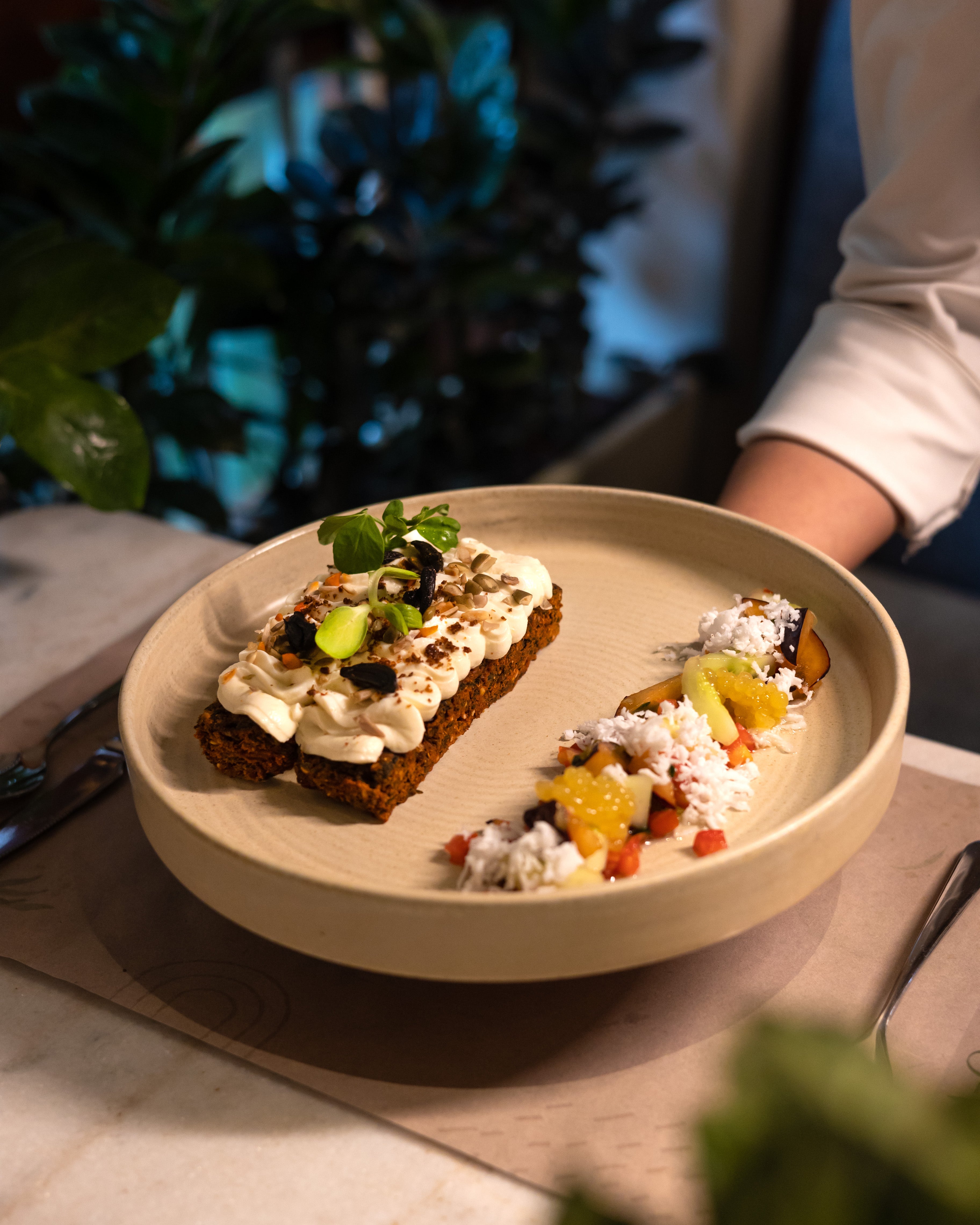 Plated dish with bread topped with cream and vegetables on a table, best organic cafés in Mumbai, vegetarian cafés in Mumbai