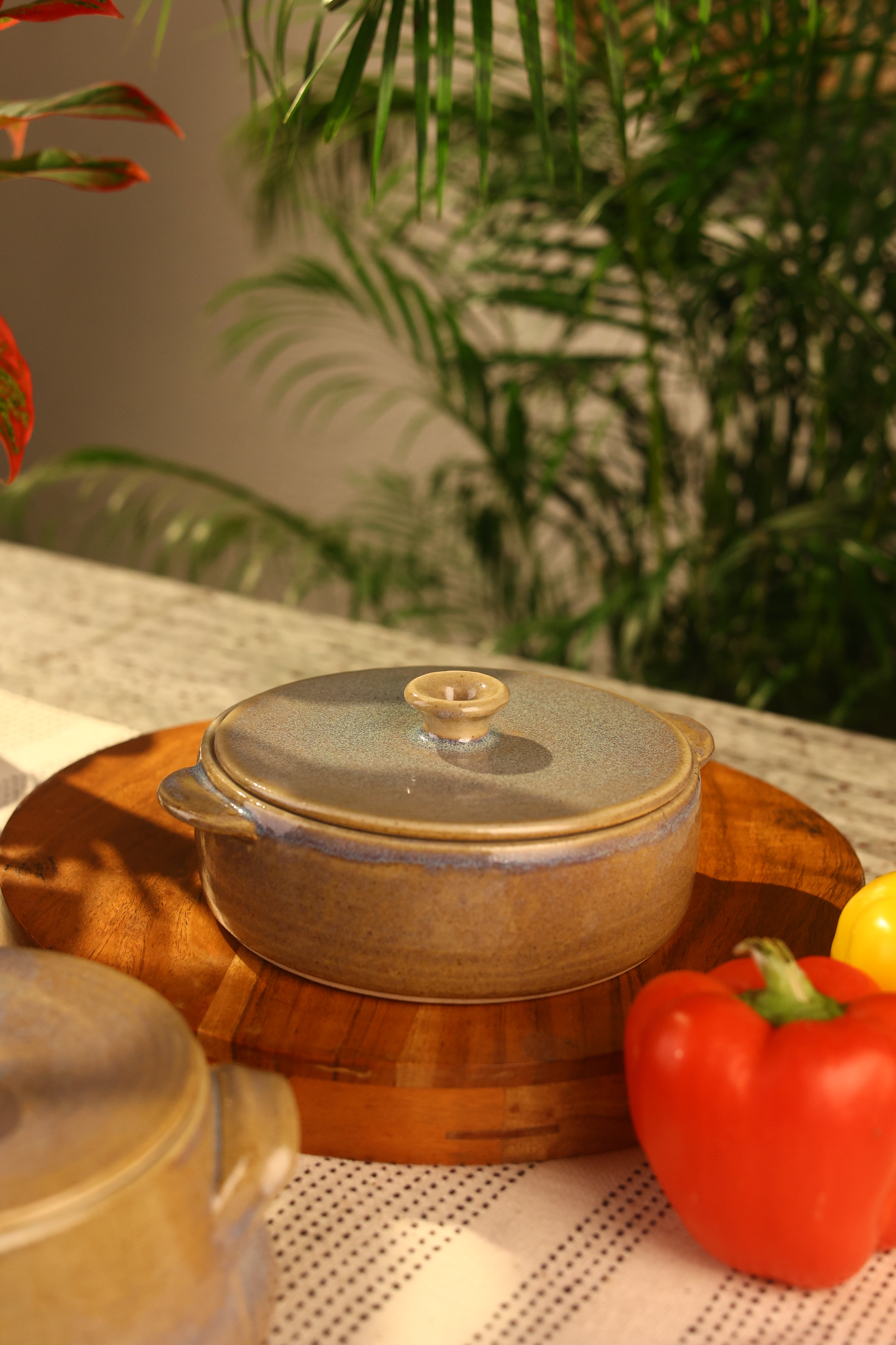 A brown pot with a lid on a surface, artisanal serveware India, handcrafted plates and bowls
