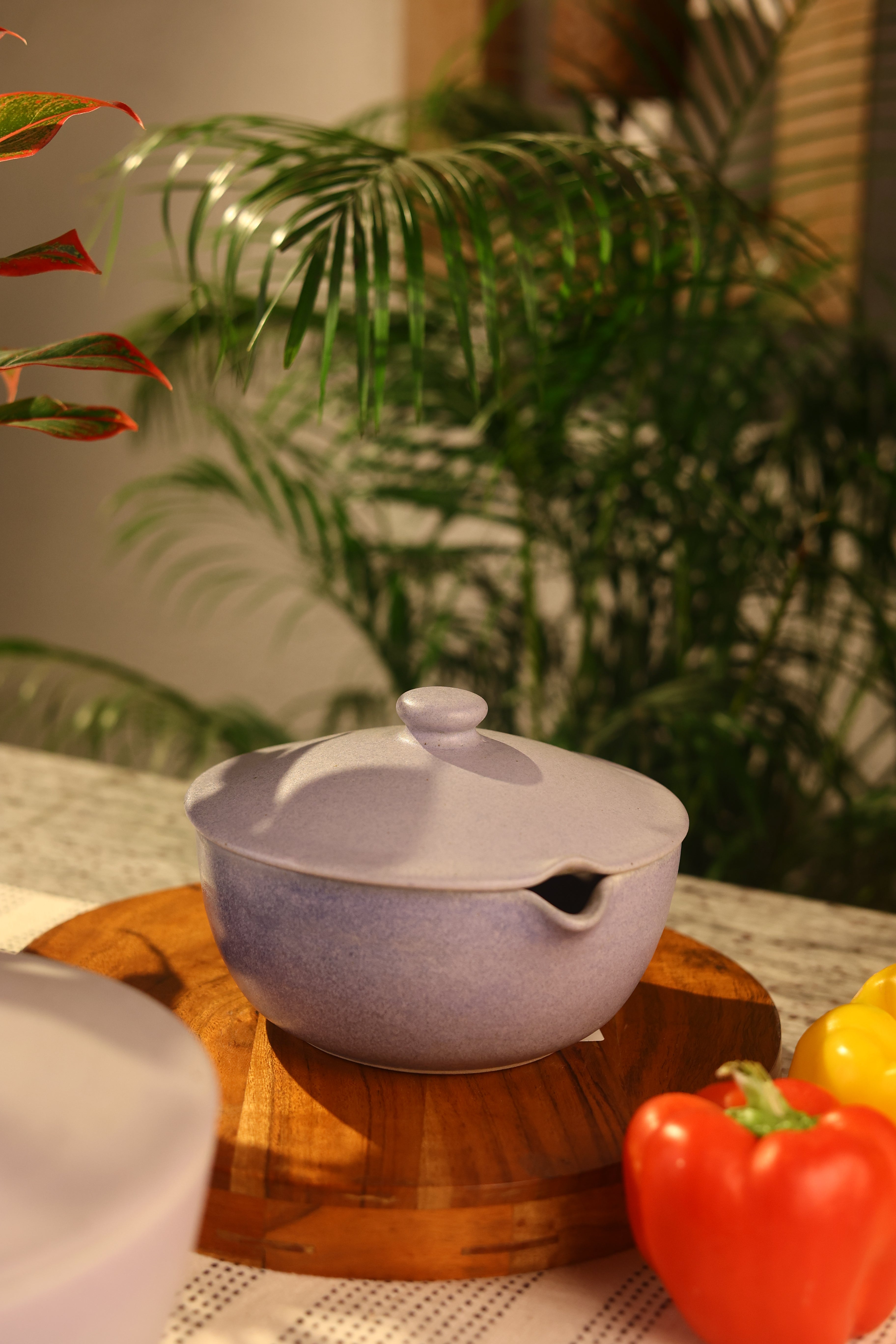 Pink ceramic pot with a lid on a wooden surface, artisanal serveware India, handcrafted plates and bowls 