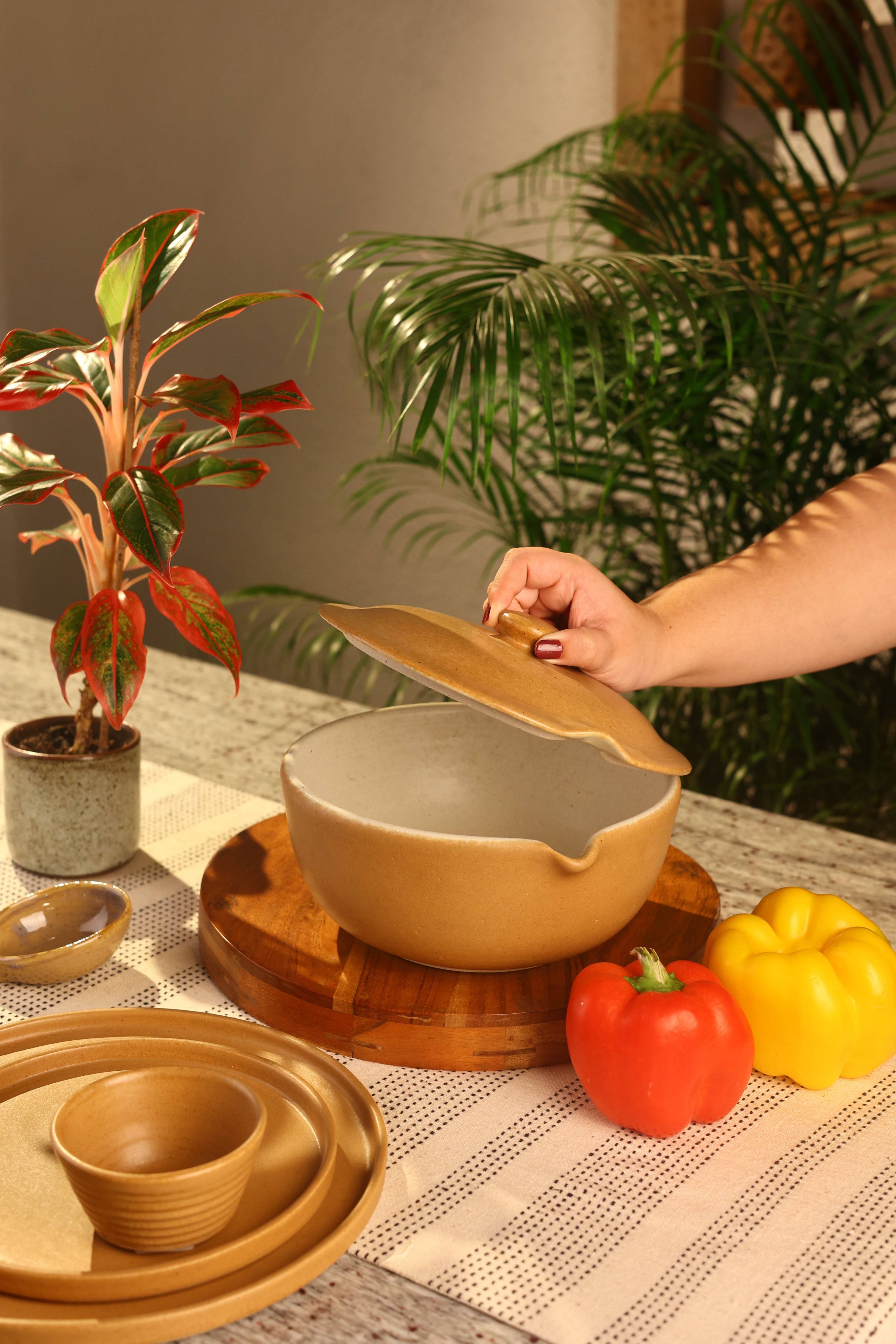 Hand holding a mustard ceramic bowl artisanal serveware India, 
handcrafted plates and bowls