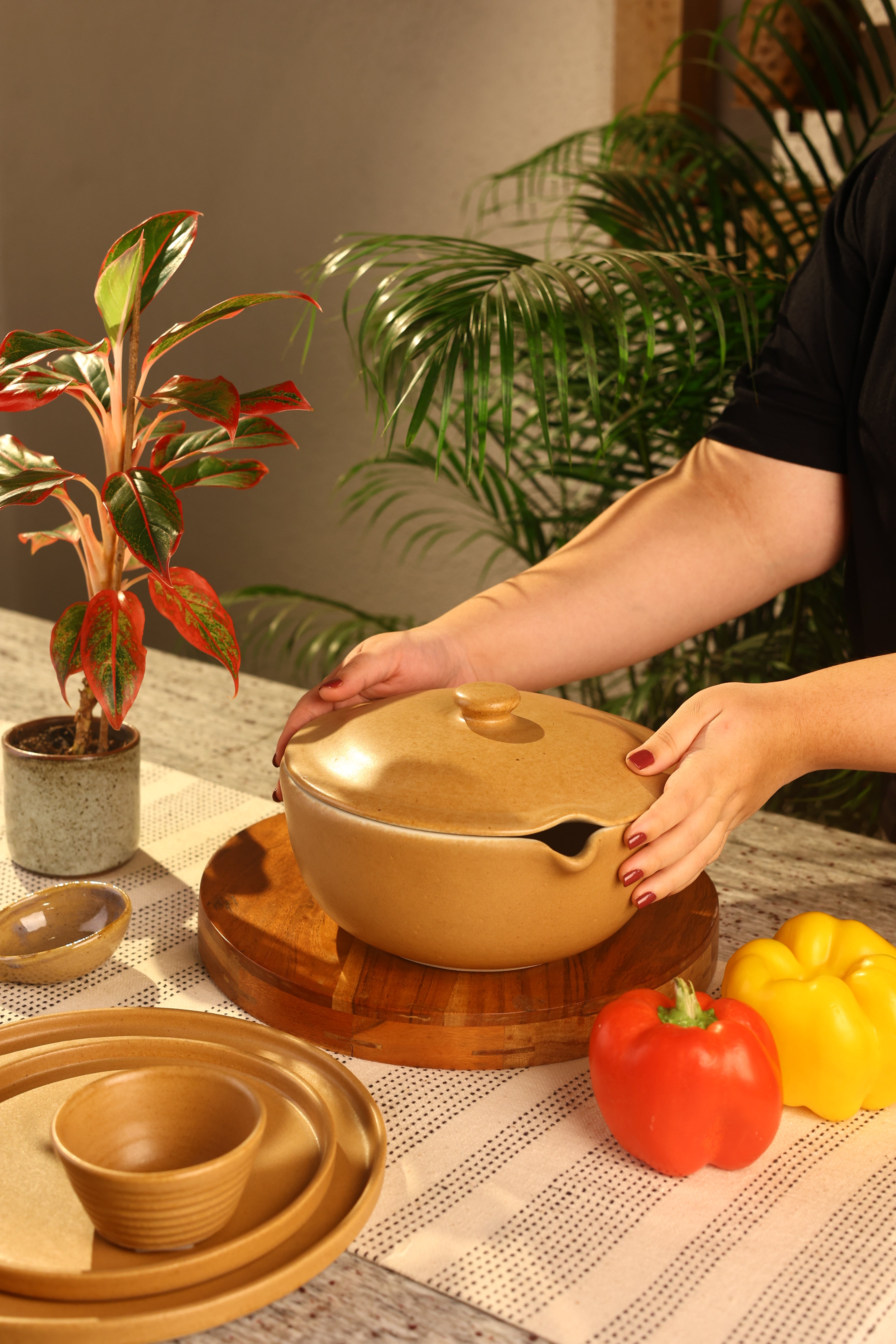 A mustard decorative pot with lid on a wooden board artisanal serveware India, handcrafted plates and bowls