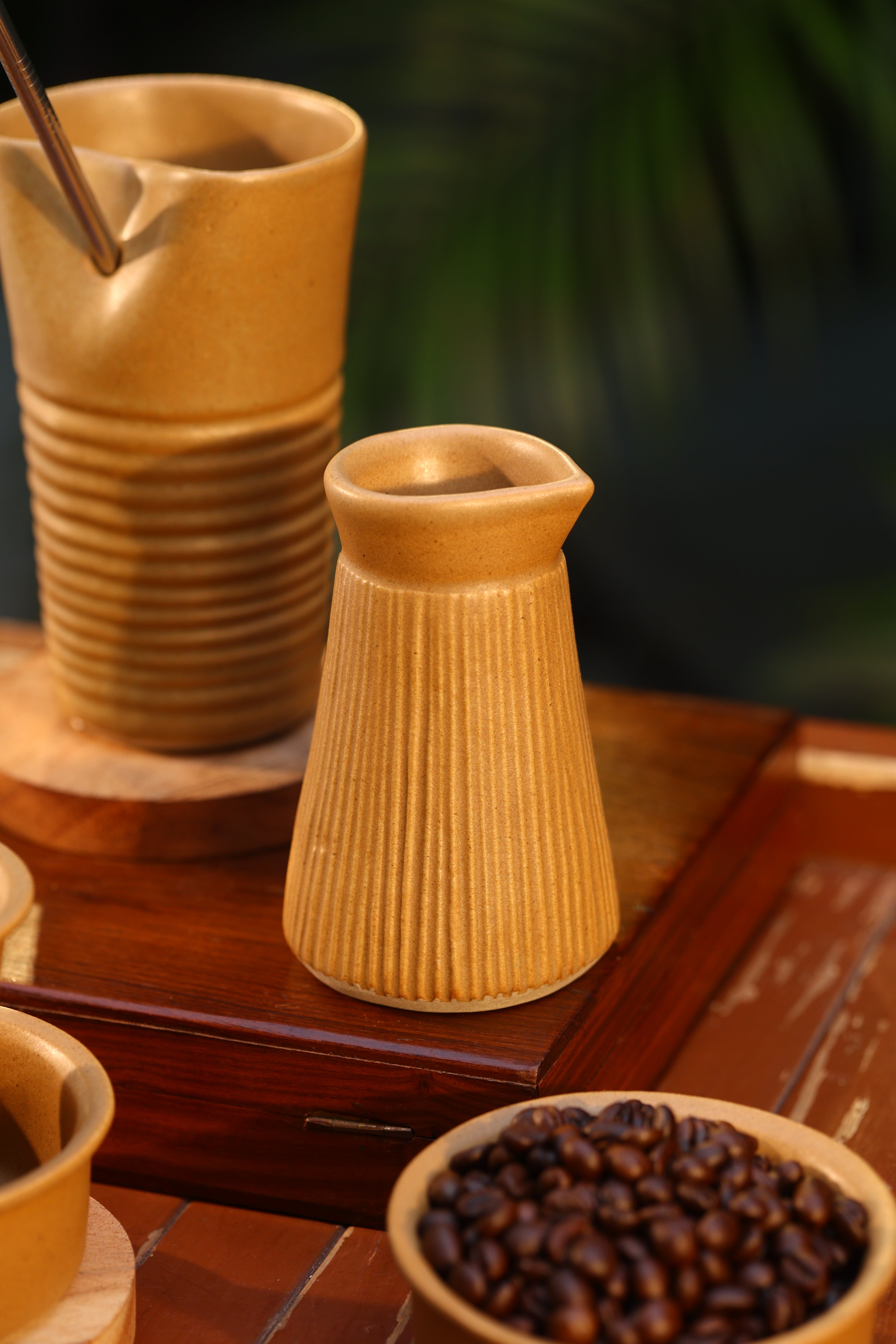 Wooden coffee grinder with coffee beans on a wooden surface, ceramic tableware India, pottery brands in India
