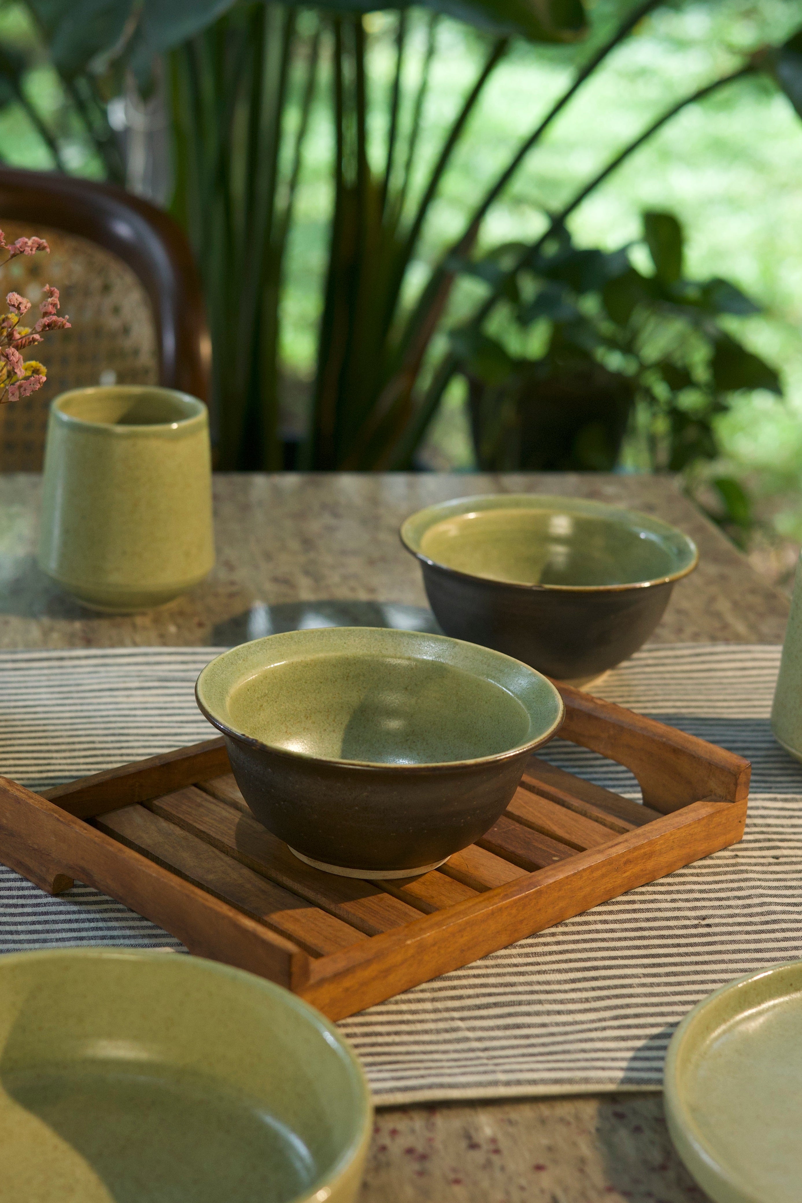 Green ceramic bowls on a wooden tray artisanal serveware India, 
handcrafted plates and bowls