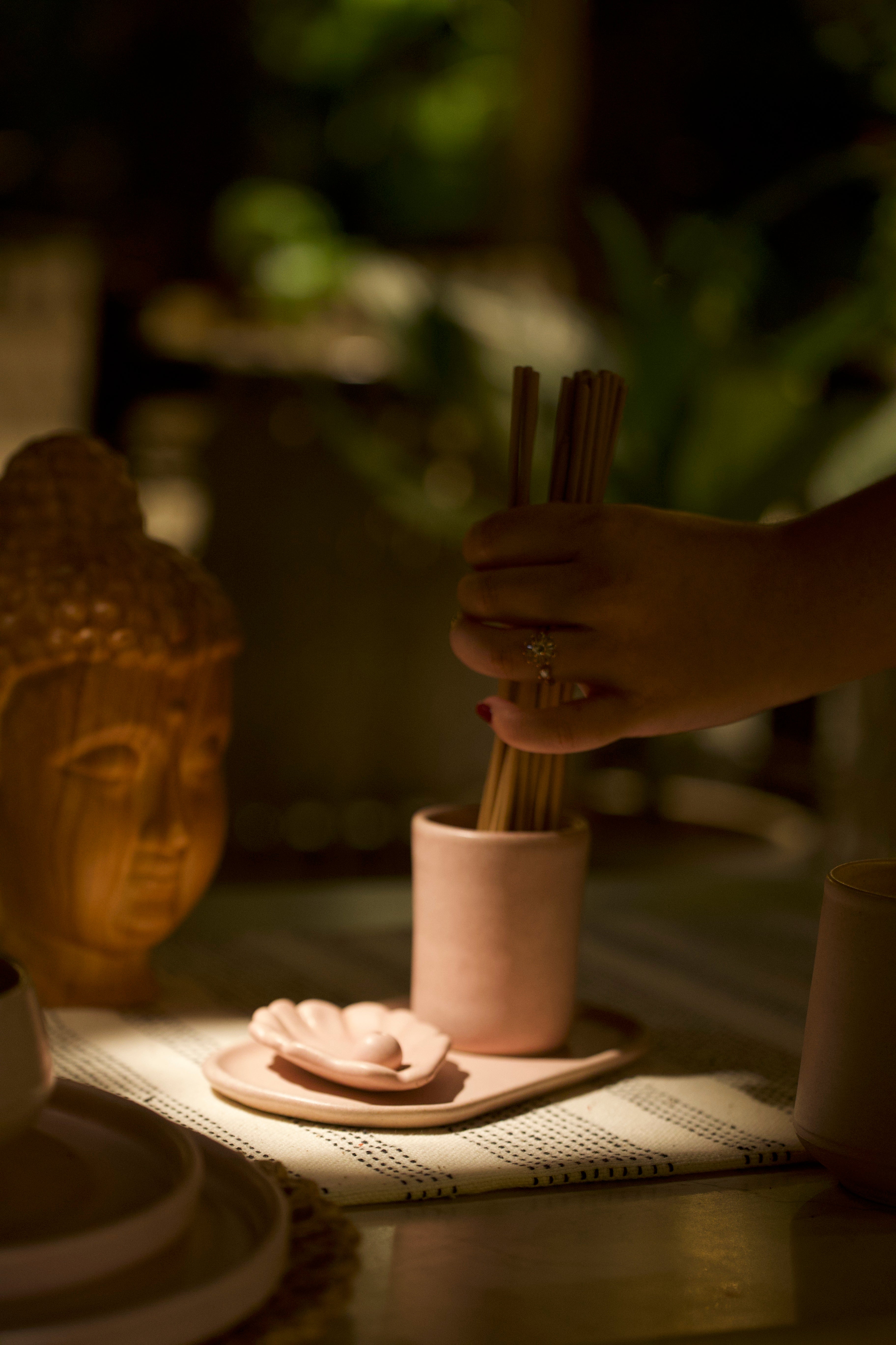 Person holding chopsticks over a pink container. sustainable home décor India, unique home gifts India