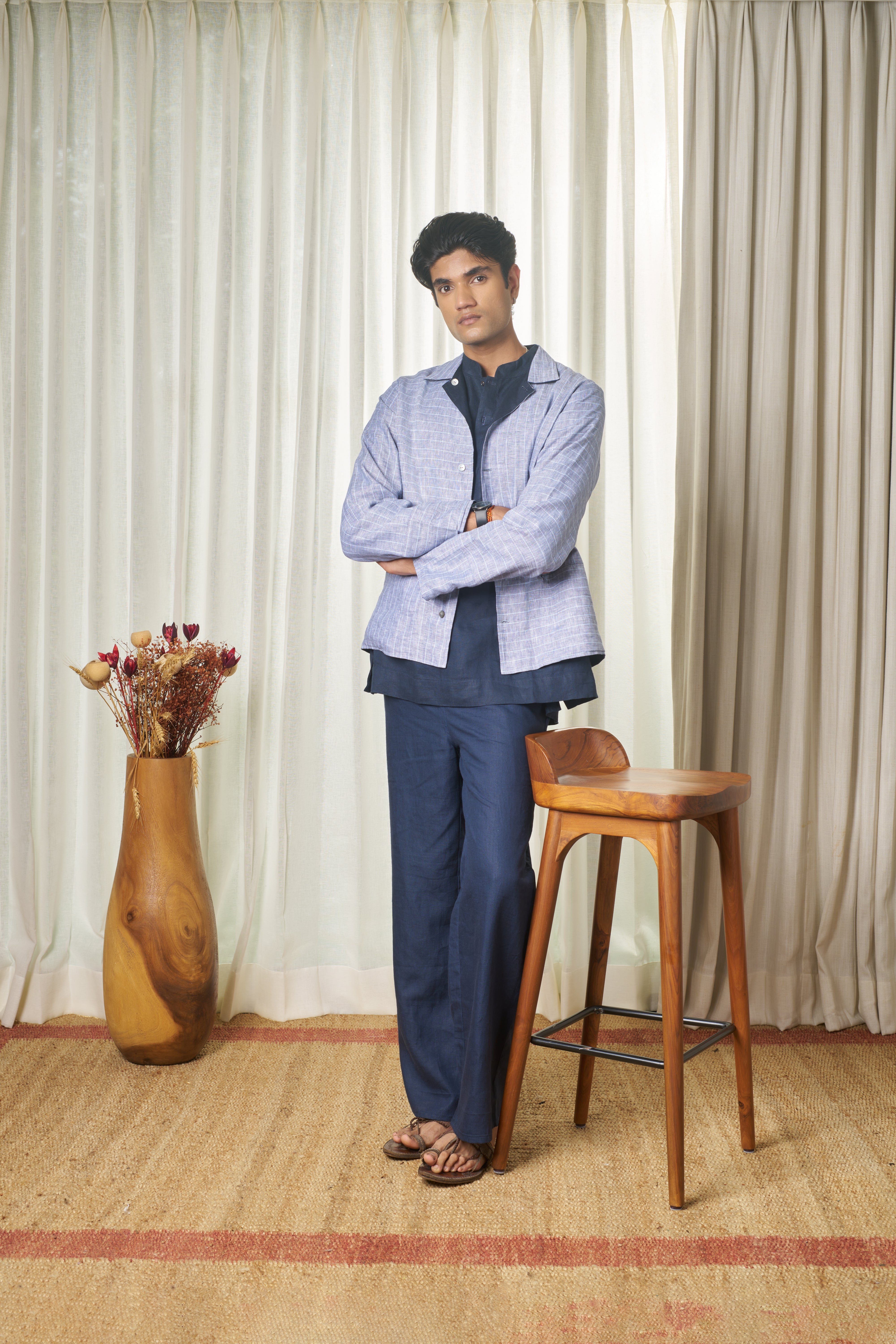 Person wearing a light blue striped shirt and dark pants. minimal menswear brands India, linen shirts for men India