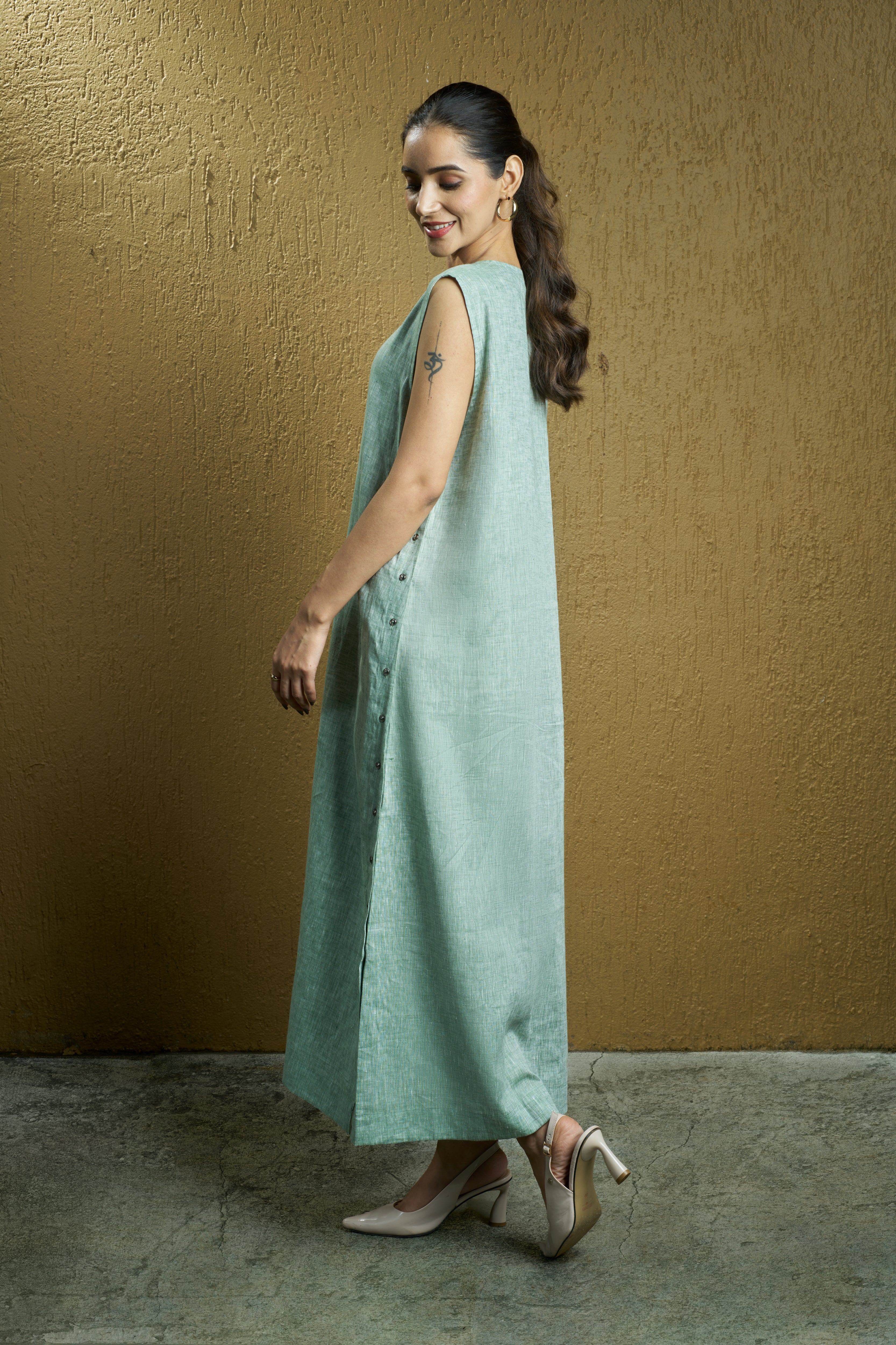 Woman wearing a mint green sleeveless dress. Womens resort wear mumbai, linen dresses shop online