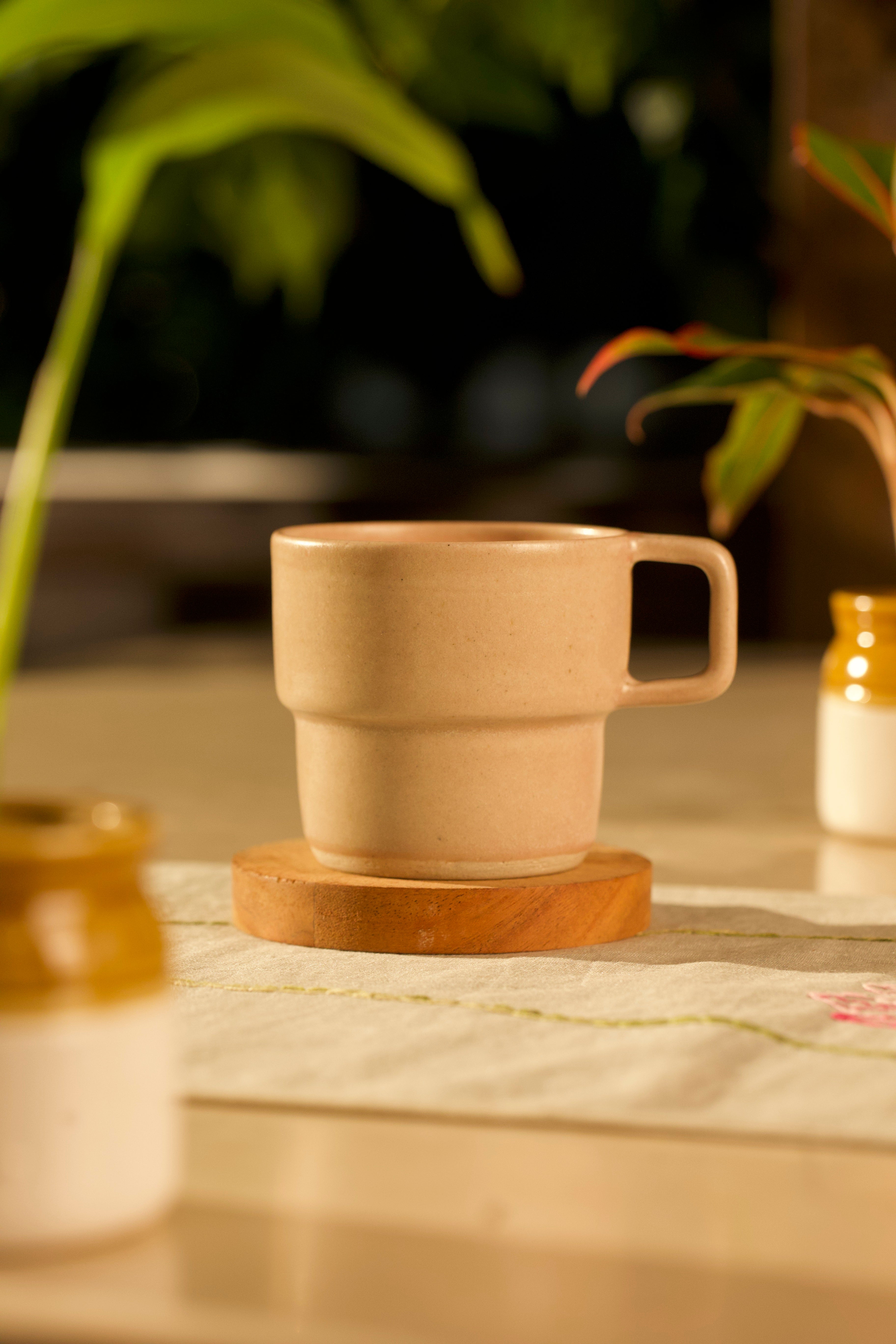 Beige ceramic cup on a wooden coaster, ceramic coffee mugs online,
Indian pottery brands online 