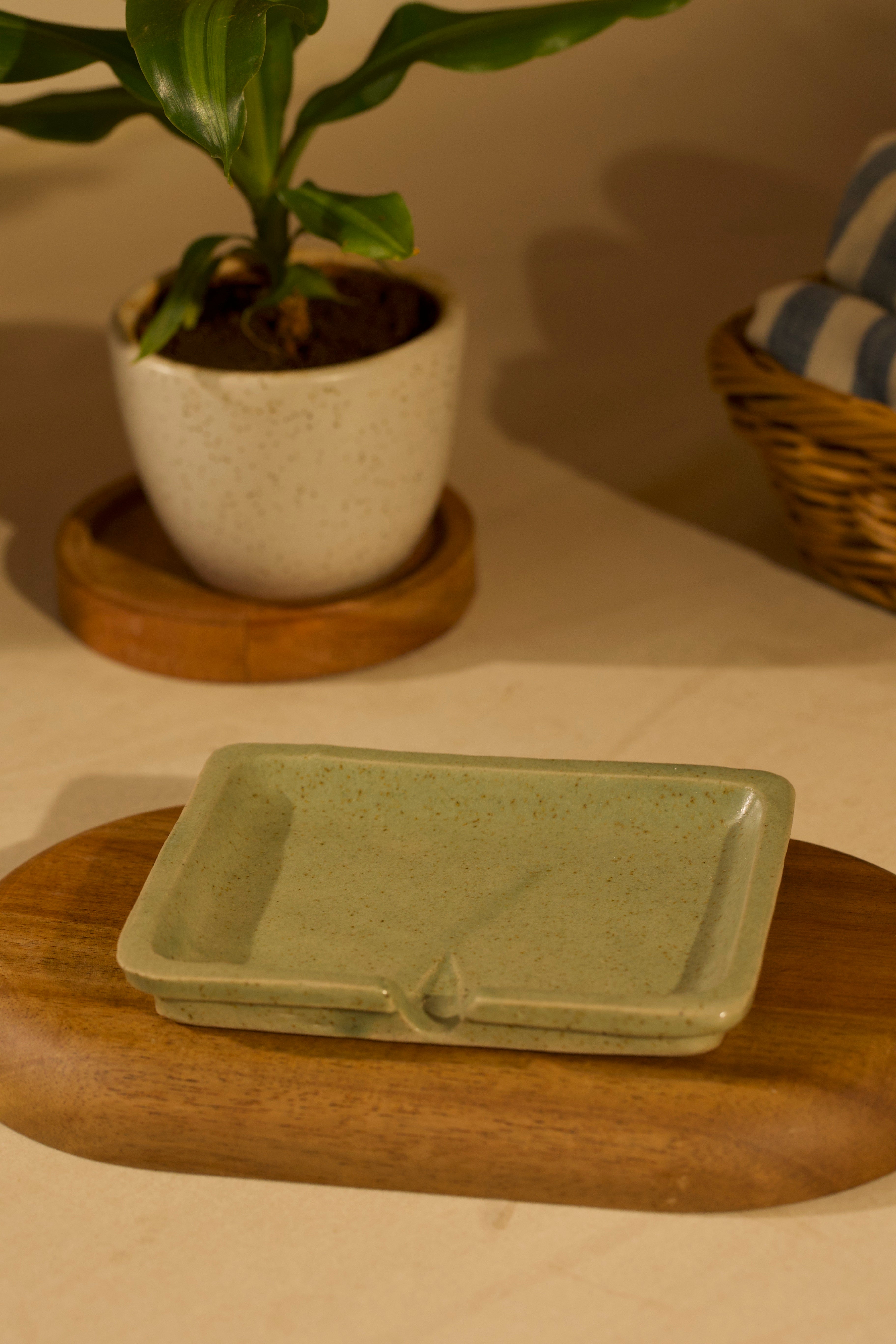 Green ceramic dish on a wooden surface . ceramic home décor online, pottery home decor