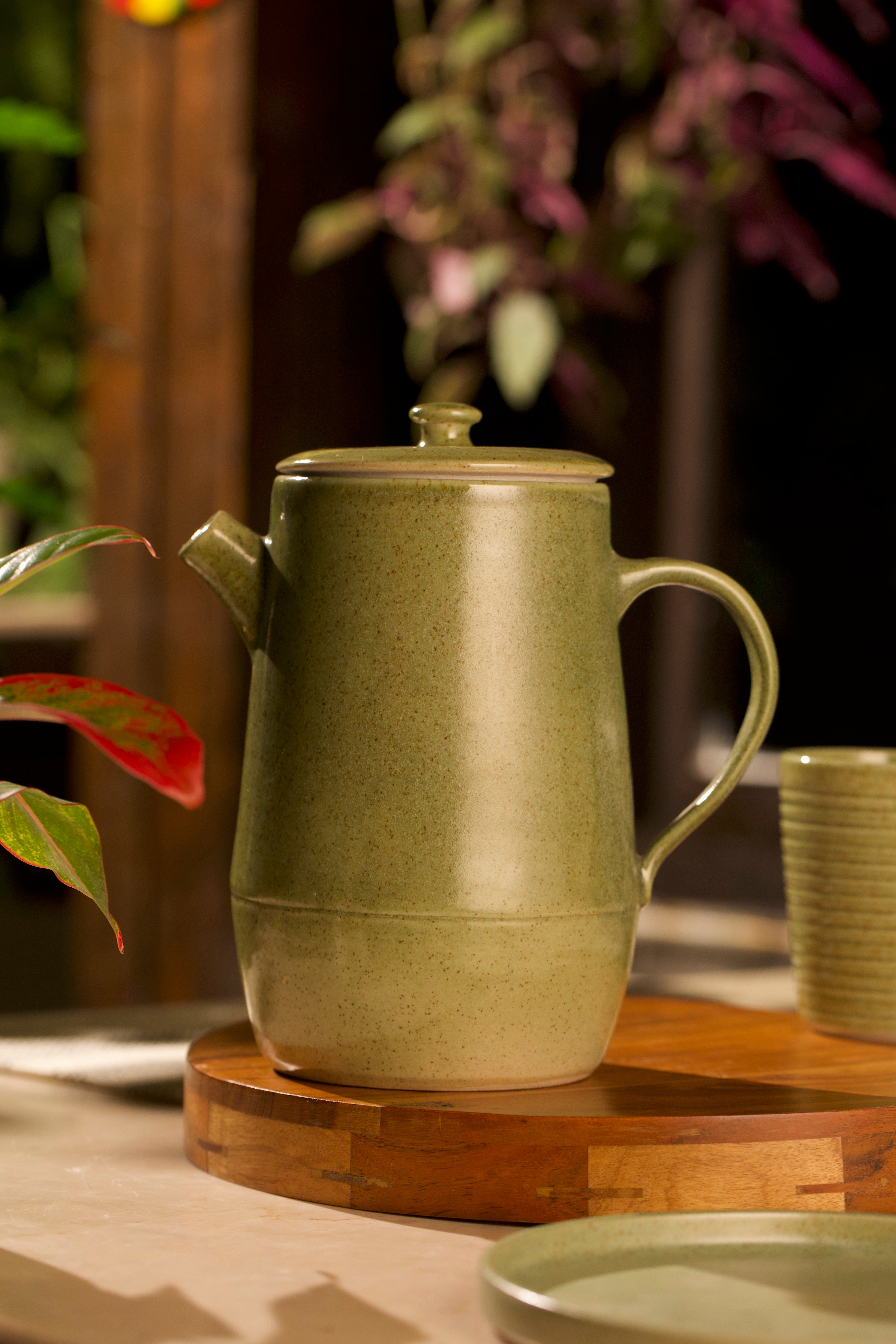 Green ceramic teapot on a wooden surface, ceramic tableware India, pottery brands in India