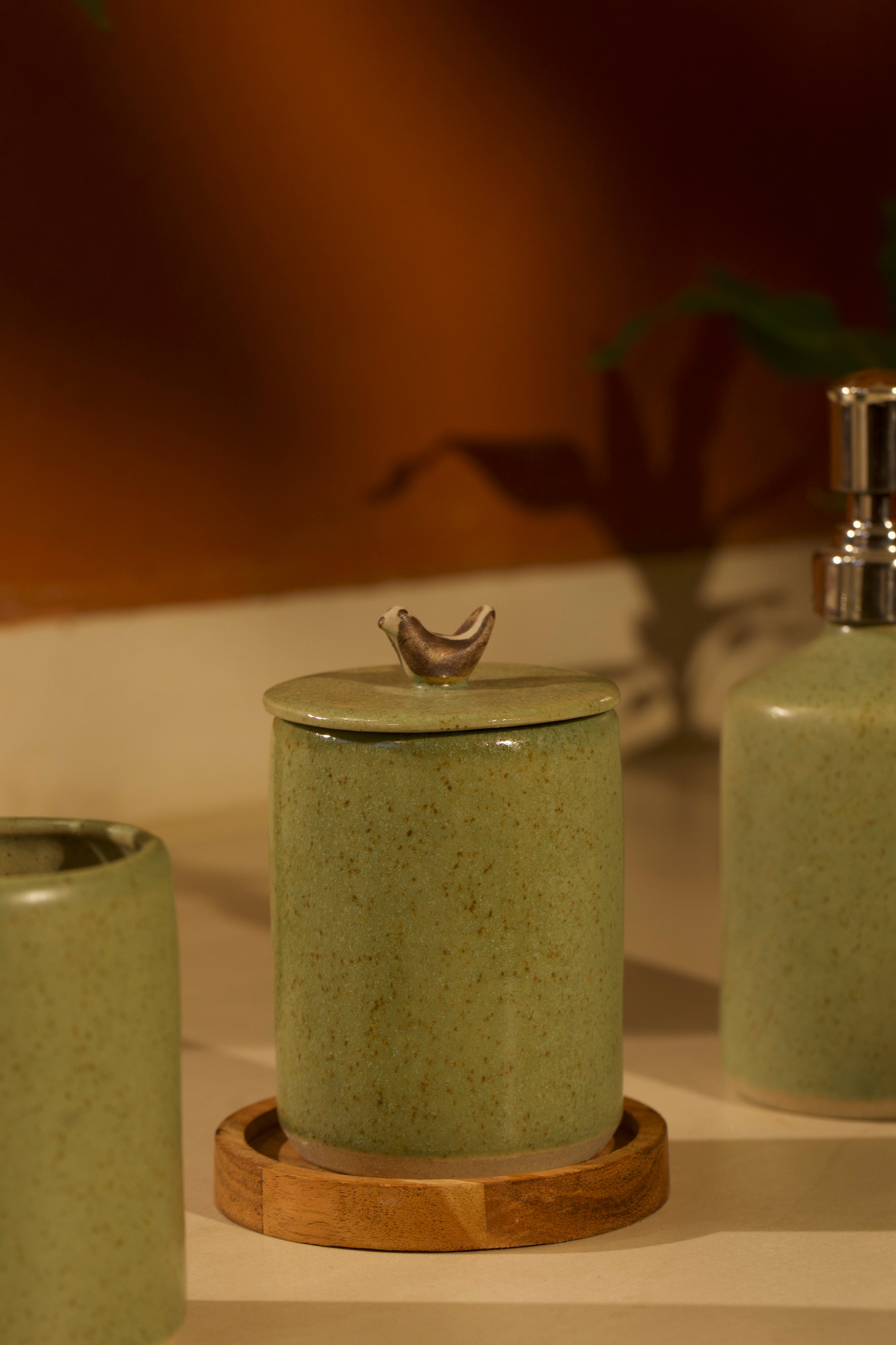 Set of green ceramic jars with a wooden coaster.  ceramic home décor online, pottery home decor