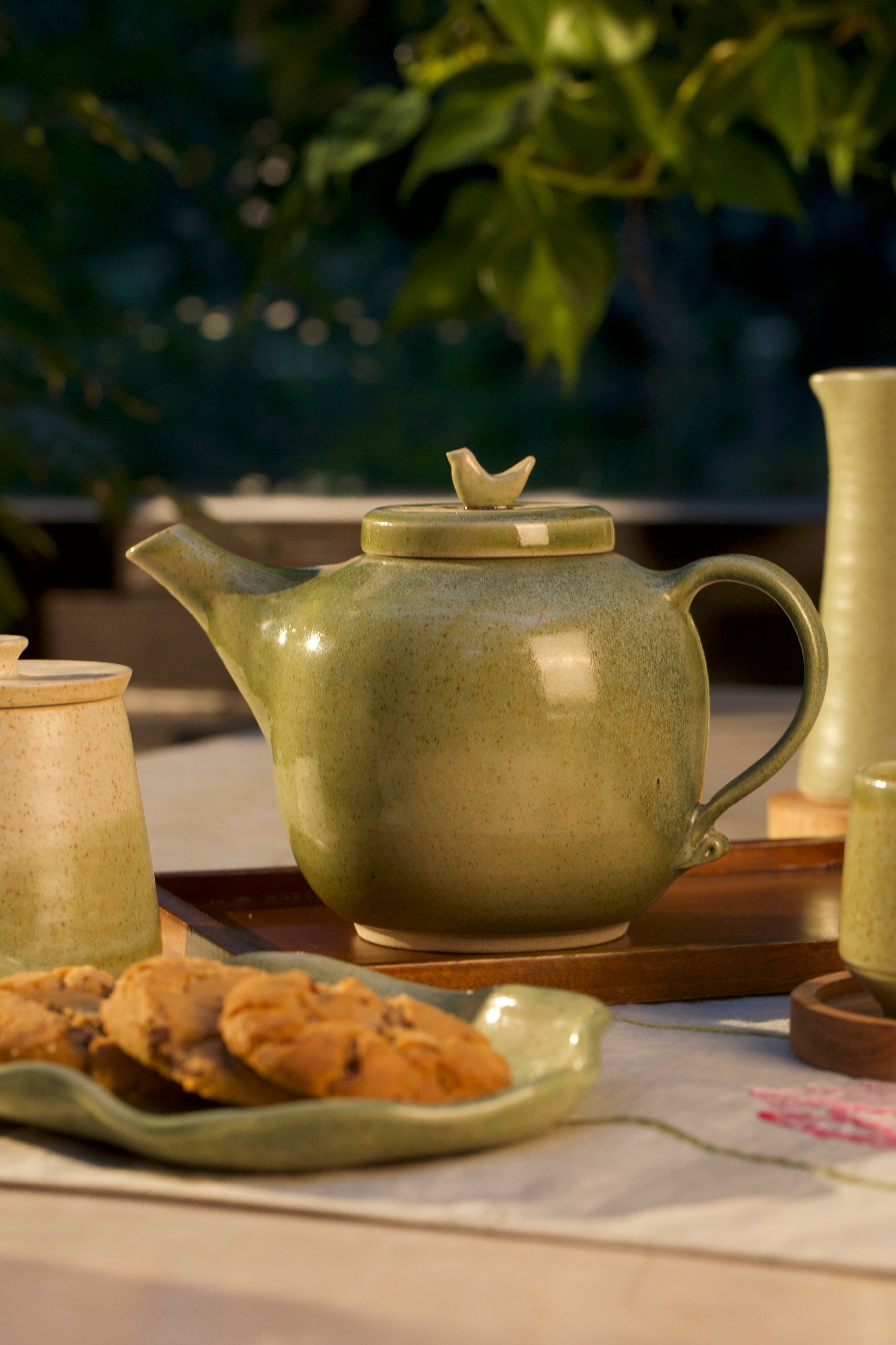 Green ceramic teapot on a wooden tray. handmade tea sets India, 
Indian pottery brands online