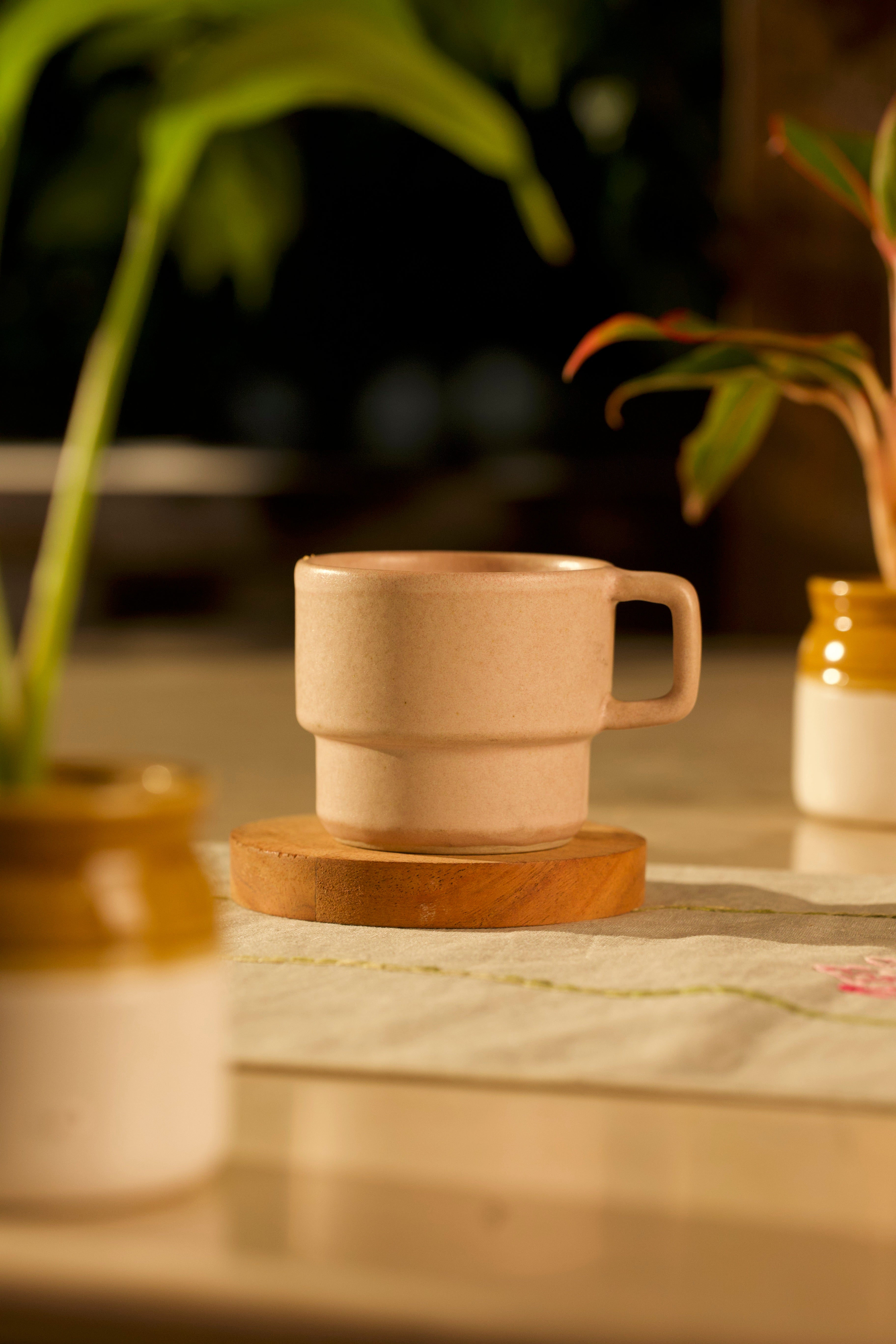 Beige ceramic cup on a wooden coaster, ceramic coffee mugs online, handmade ceramics India 