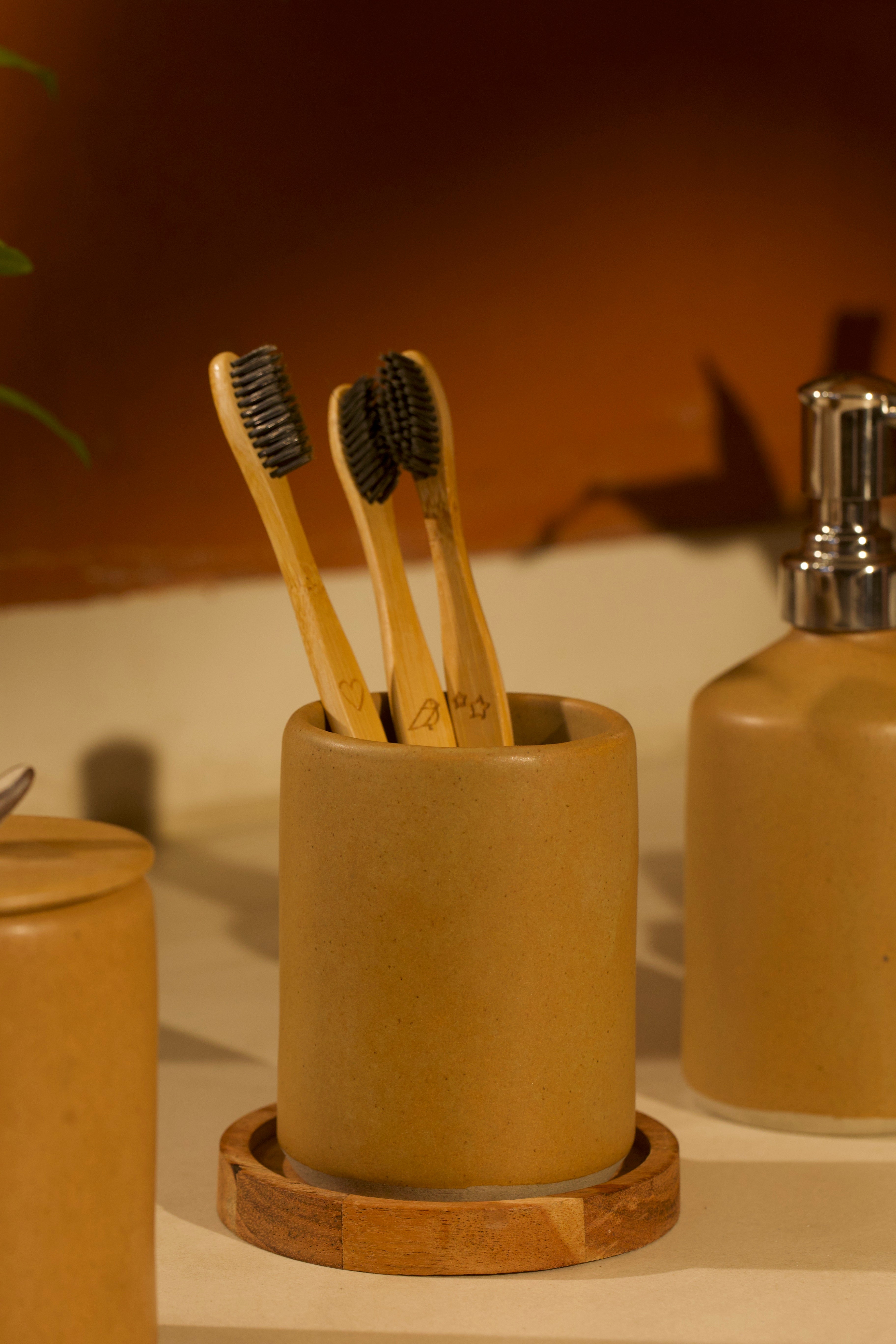 A ceramic toothbrush holder on a bathroom counter.  ceramic home décor online, pottery home decor
